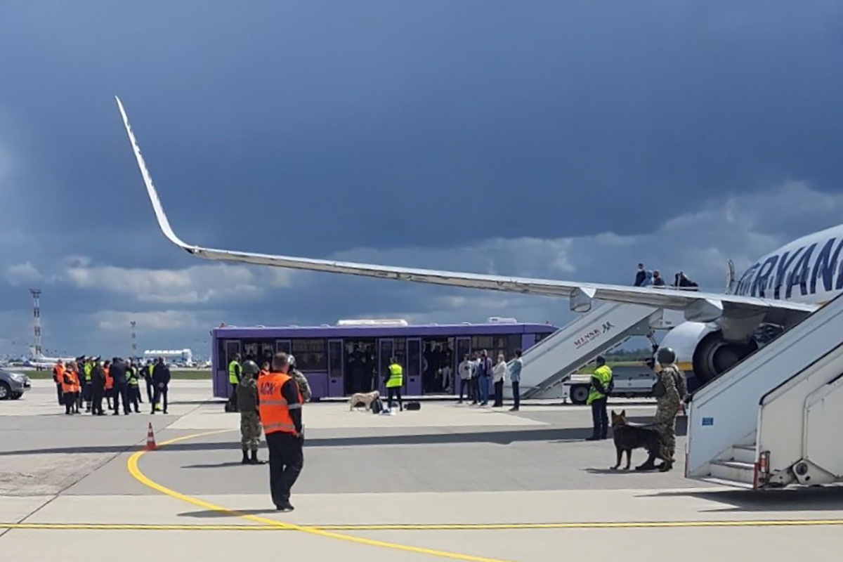 Airport personnel and security forces are seen on the tarmac in front of a Ryanair flight which was forced to land in Minsk