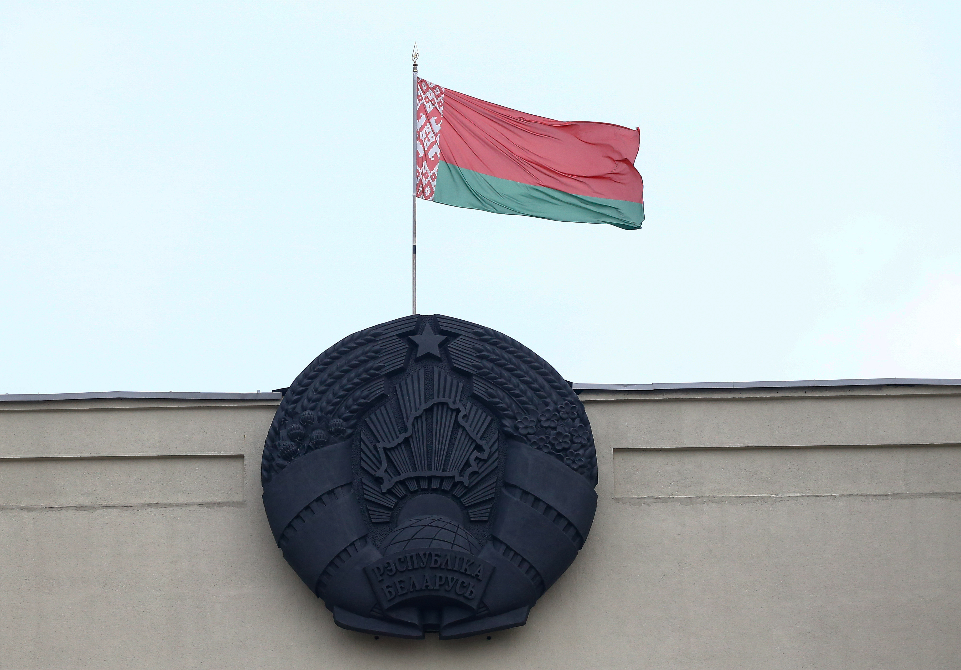 Belarusian state flag and emblem are seen on a building at Independence Square in Minsk