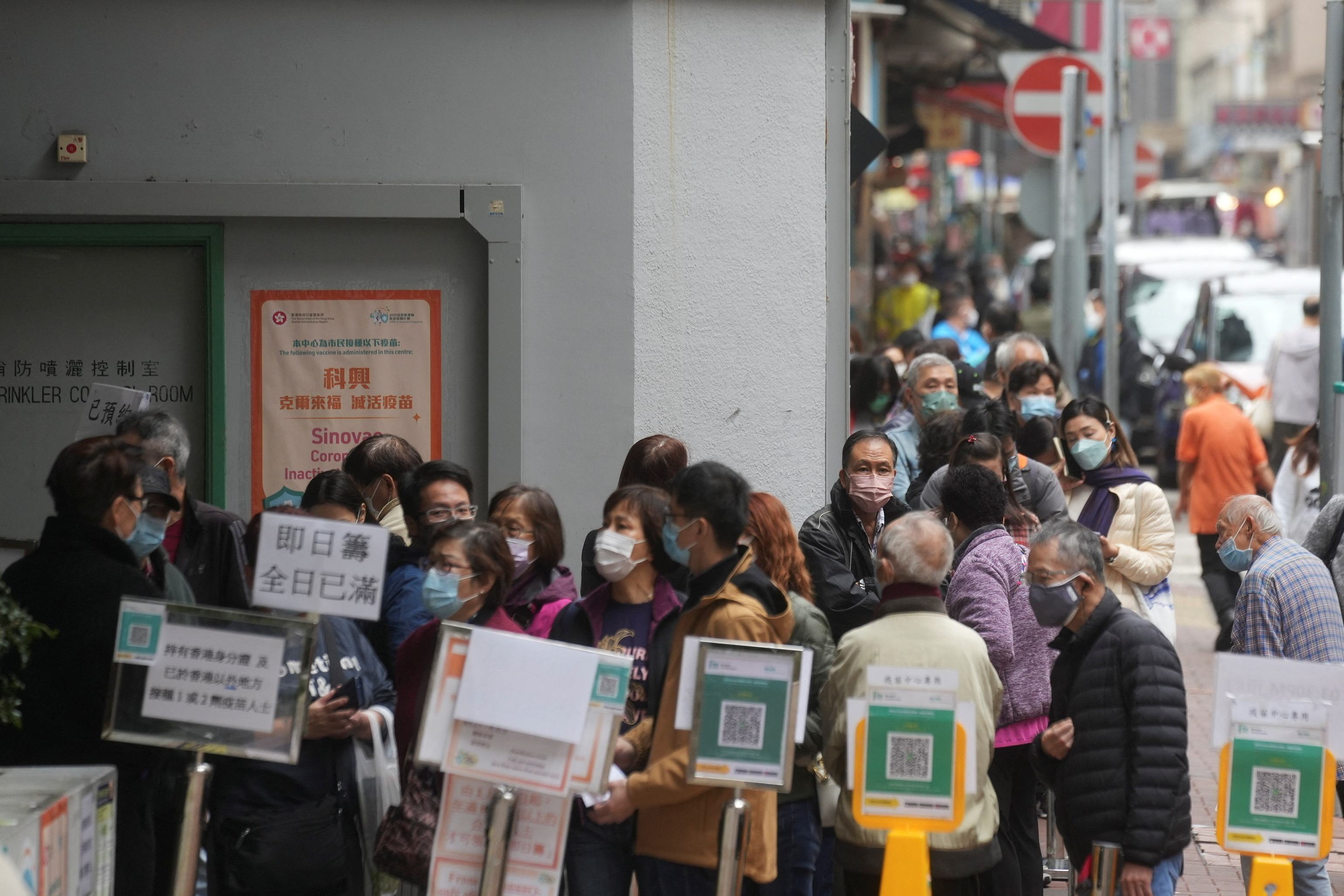 People wearing face masks queue outside a community vaccination centre to receive a dose of Sinovac Biotech's CoronaVac COVID-19 vaccine, in Hong Kong