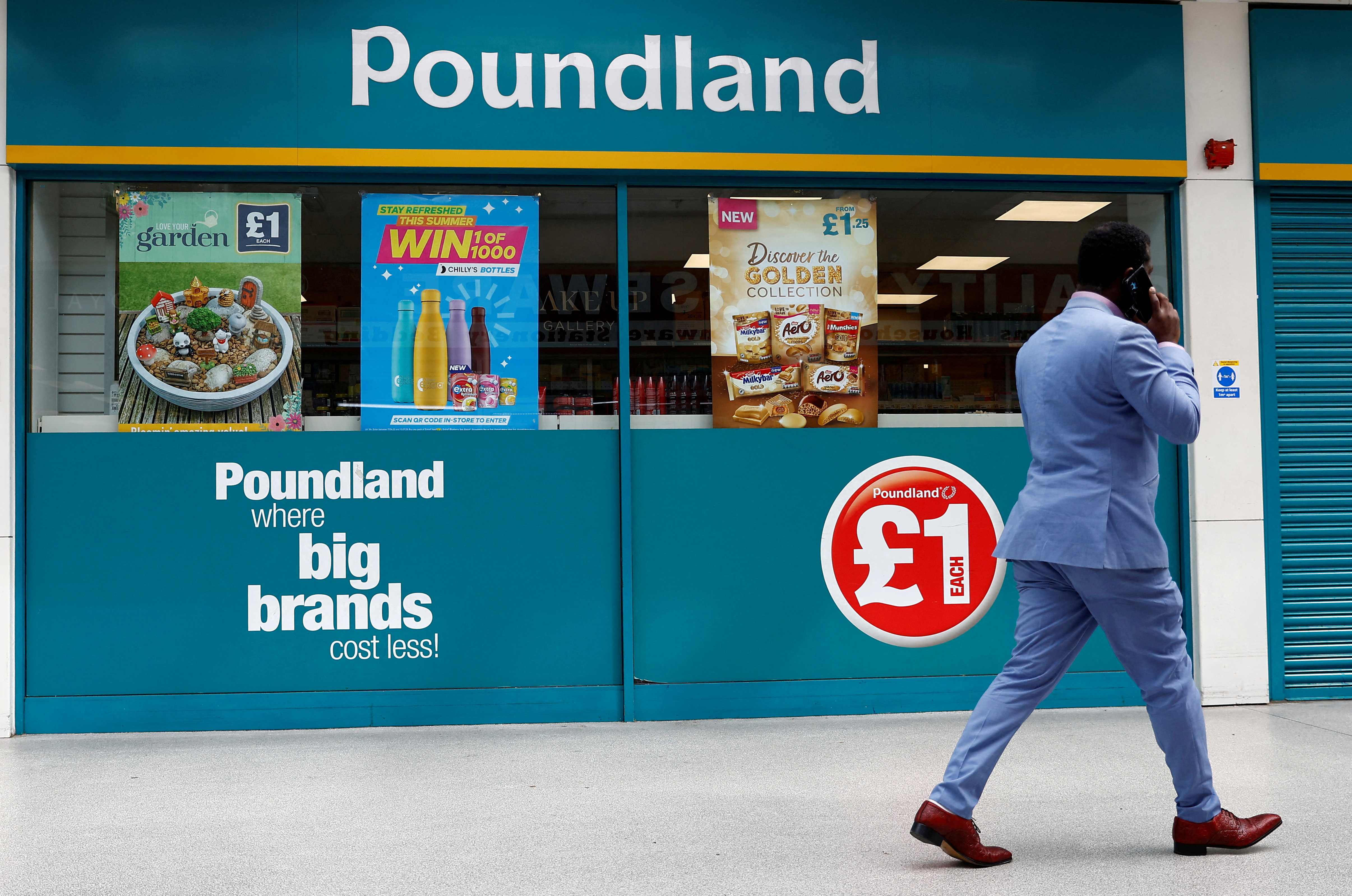 A man walks past a Poundland store in London