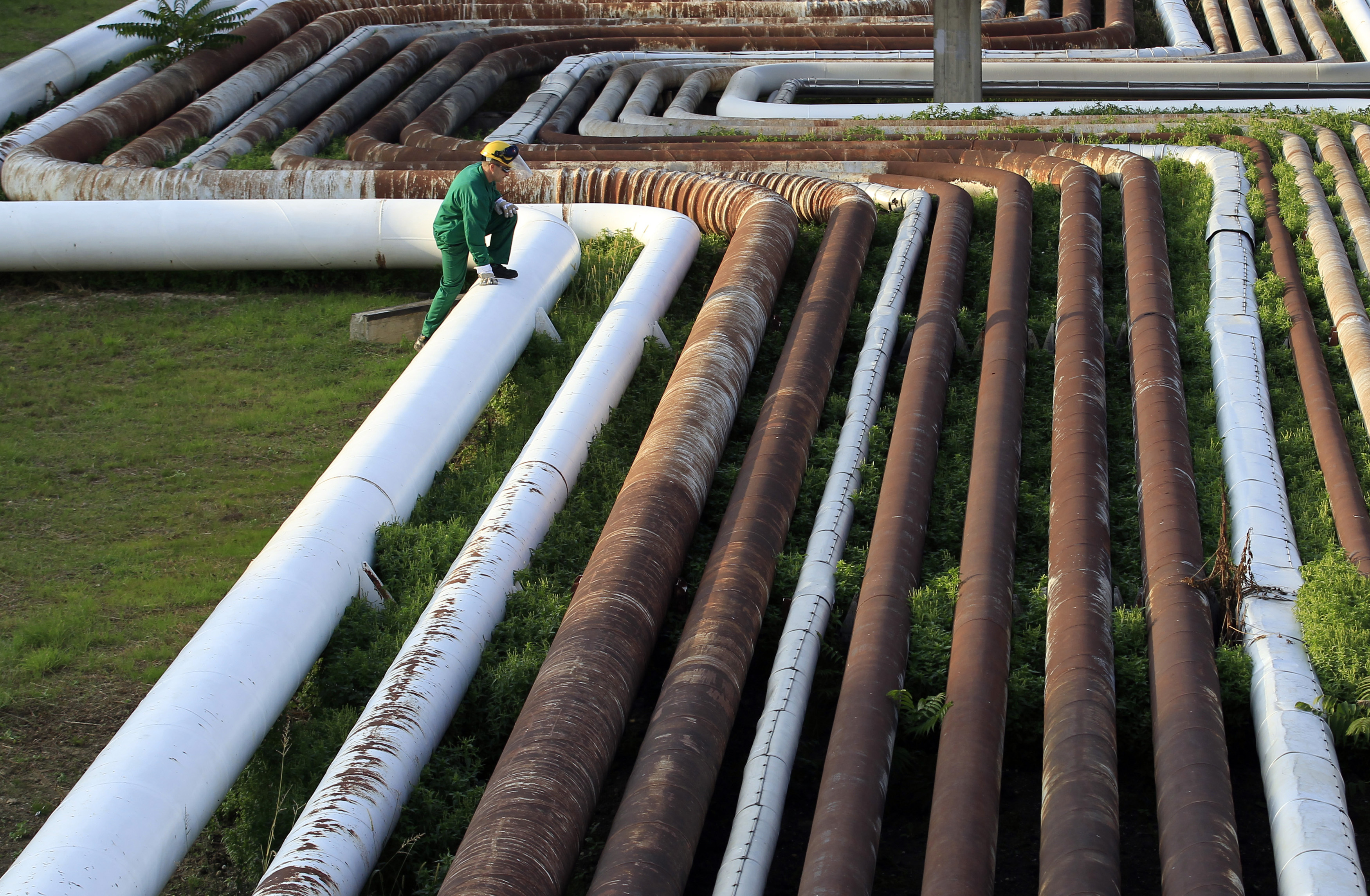 Employee walks on top of pipelines at Hungarian oil and gas group MOL's main Duna refinery in Szazhalombatta