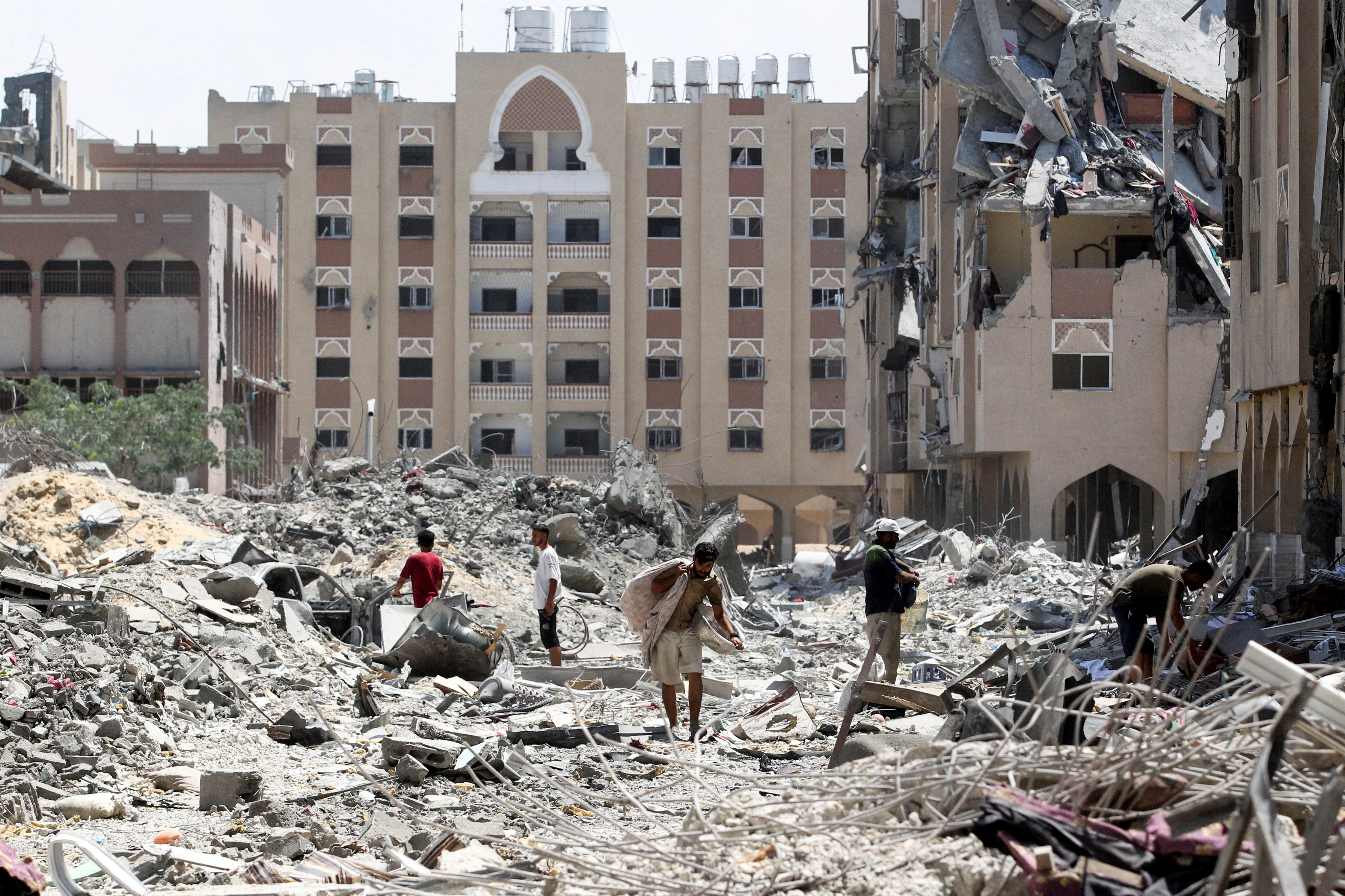 Palestinians inspect damage in Qatari-funded Hamad City, in Khan Younis