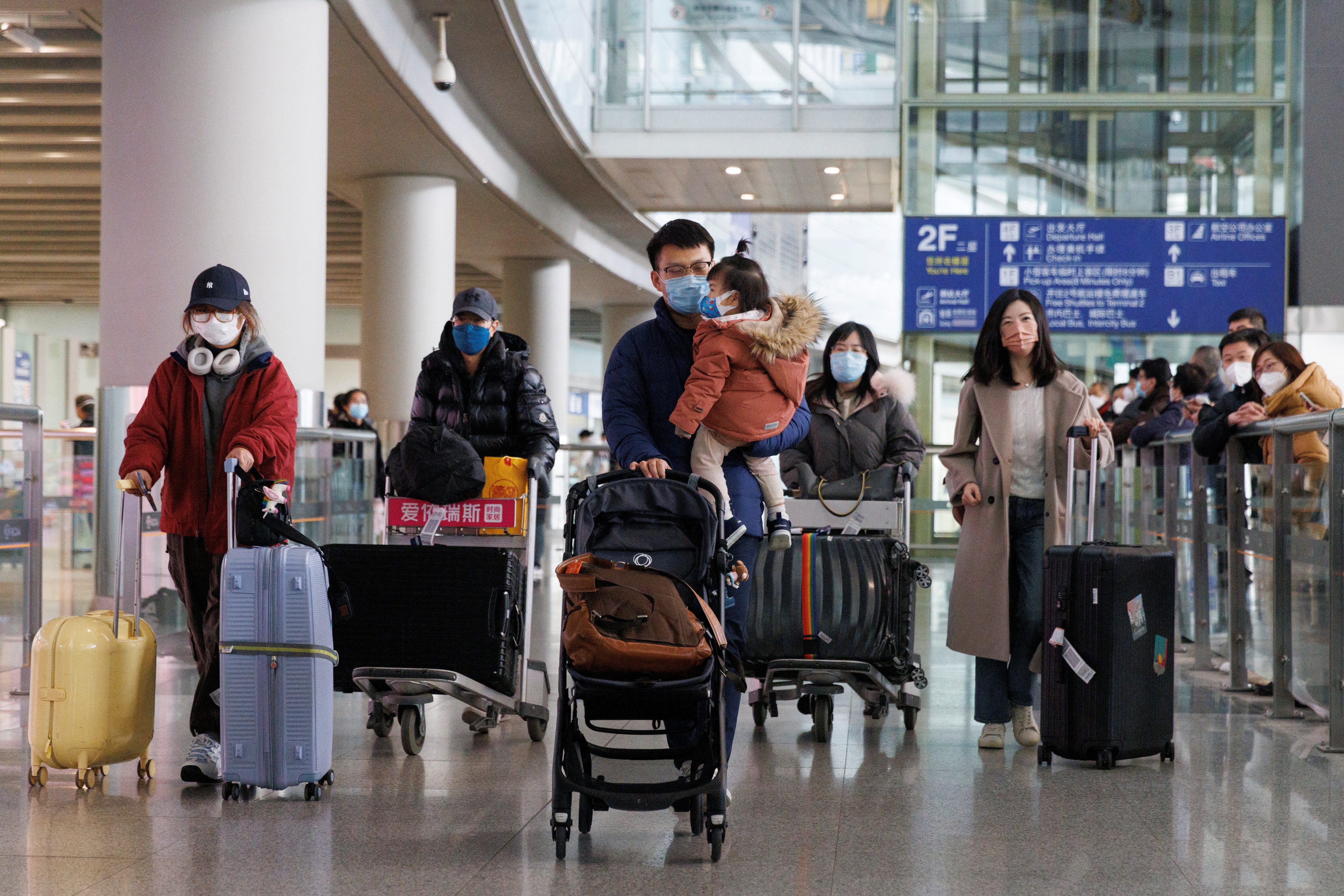 Passengers push their luggage through the international arrivals hall at Beijing Capital International Airport after China lifted its COVID-19 quarantine requirement for travelers arriving in Beijing.