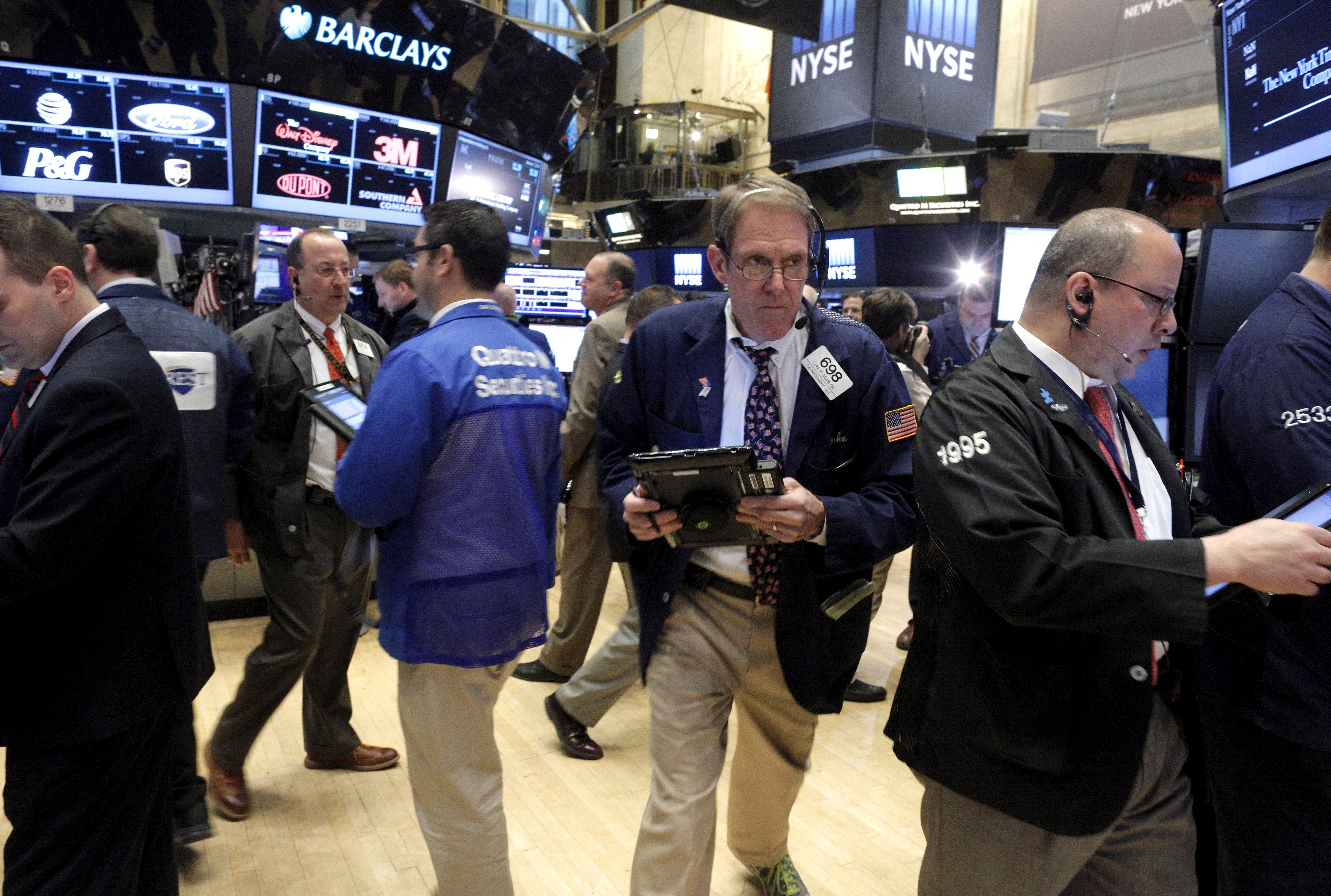 FILE PHOTO: Traders work on the floor of the New York Stock Exchange (NYSE) shortly after the opening bell of trading session in New York