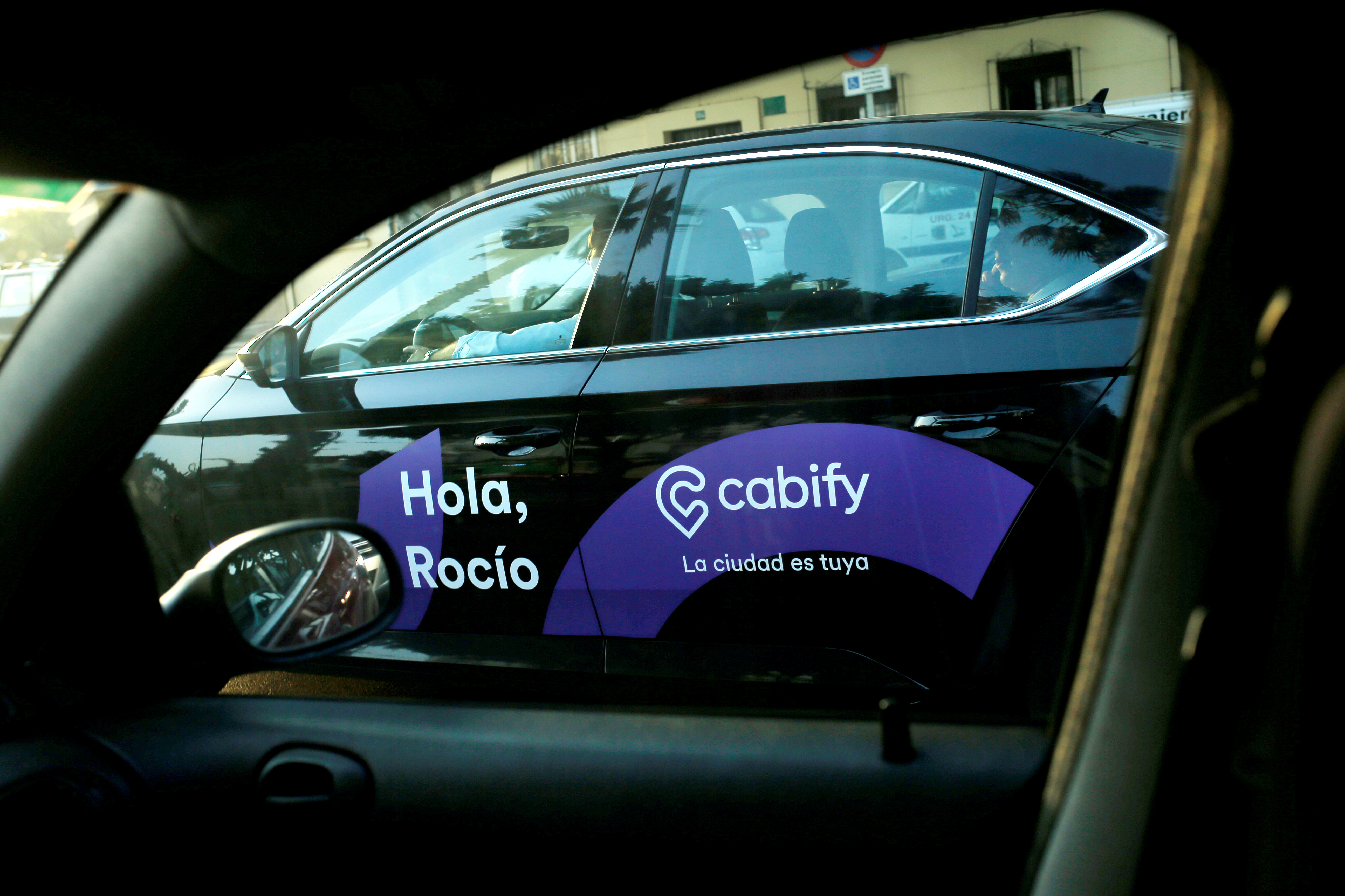 A Cabify taxi car is seen through the window of a car in Malaga