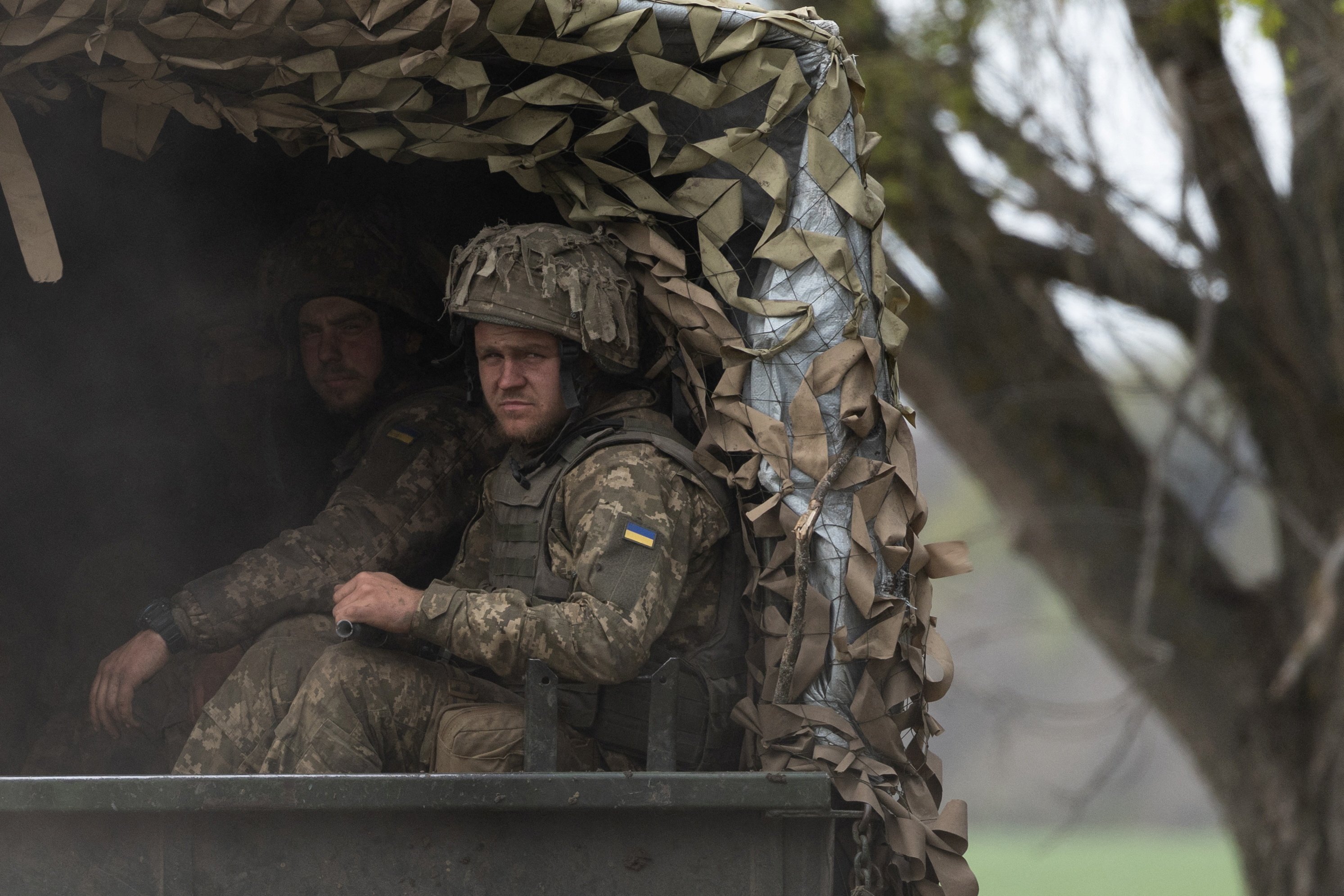 Ukrainian soldiers ride in a military vehicle to the front line during a fight, amid Russia's invasion in Ukraine, near Izyum