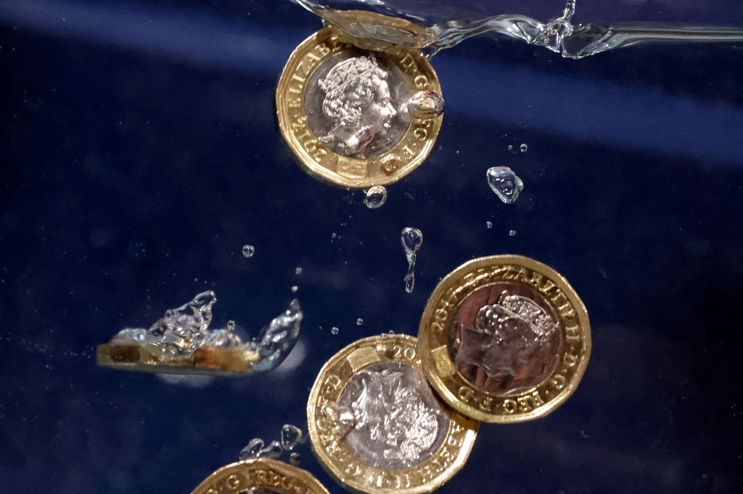 Illustration shows Pound coins plunging into water