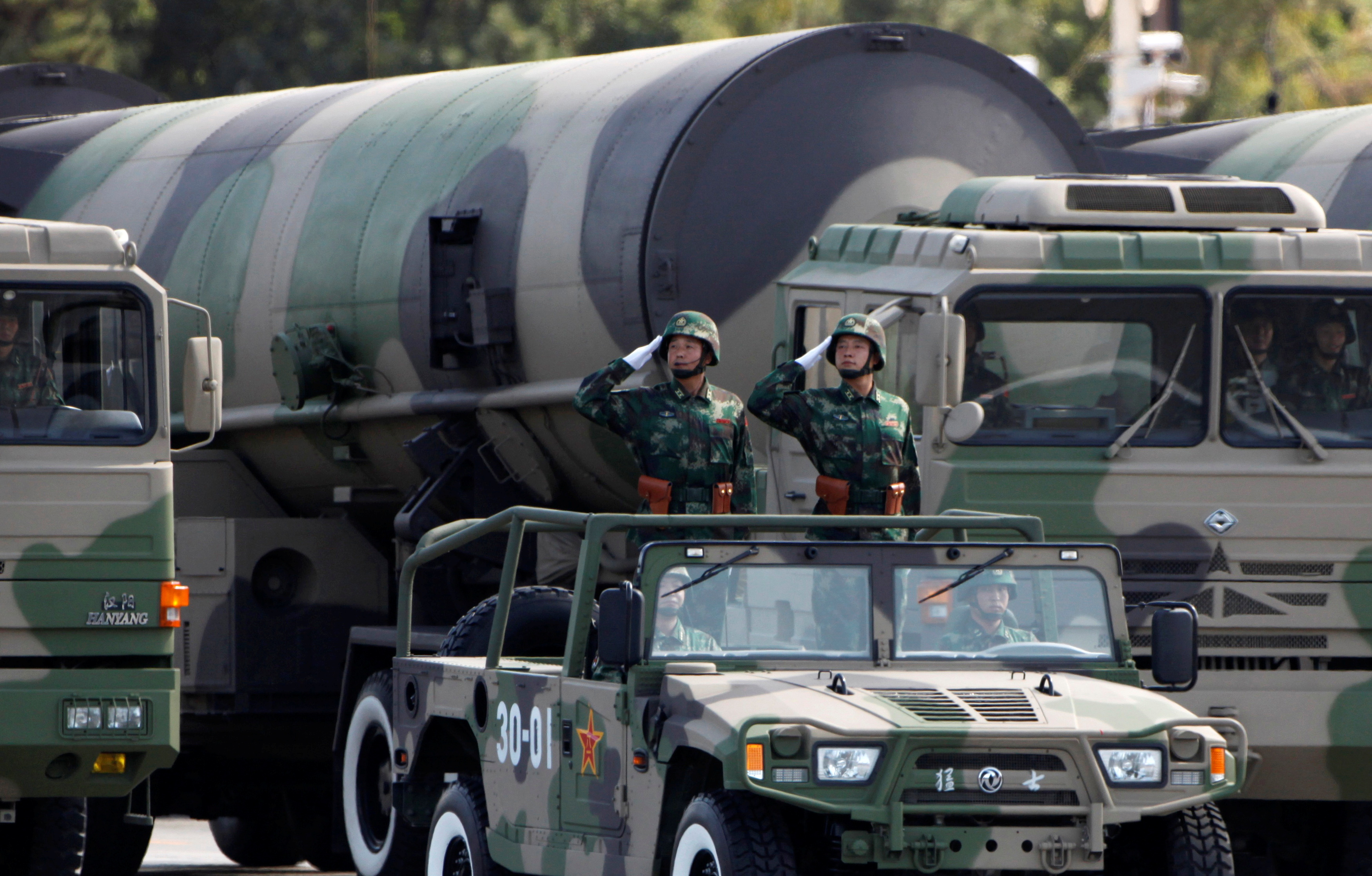 PLA soldiers salute in front of nuclear-capable missiles during a parade in Beijing
