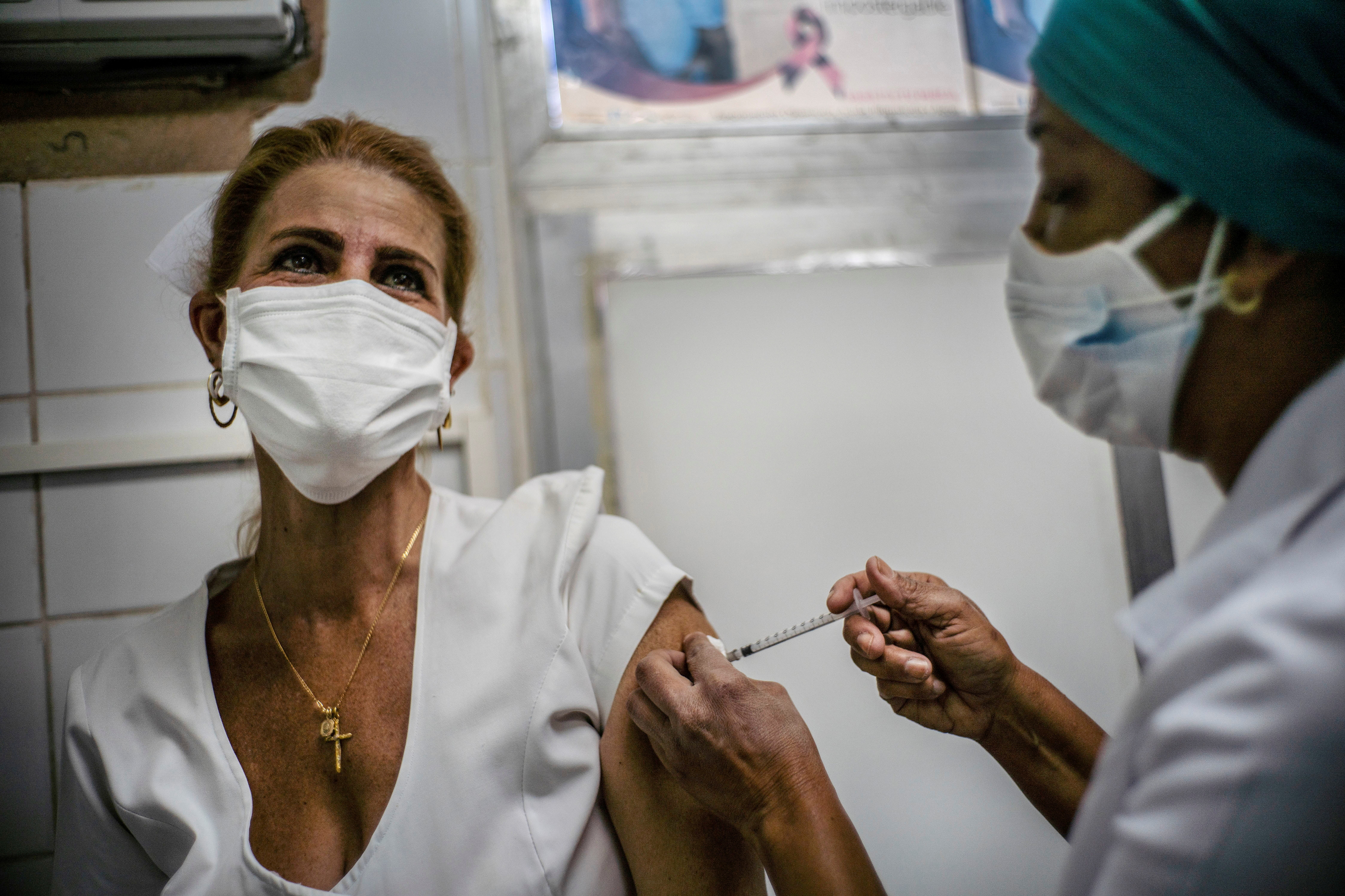 A nurse applies a dose of the Soberana-02 COVID-19 vaccine to a health worker, as part of Phase III trials of the experimental Cuban vaccine candidate amid concerns about the spread of the coronavirus disease, in Havana, Cuba, March 24, 2021. Ramon Espinosa / Pool via REUTERS