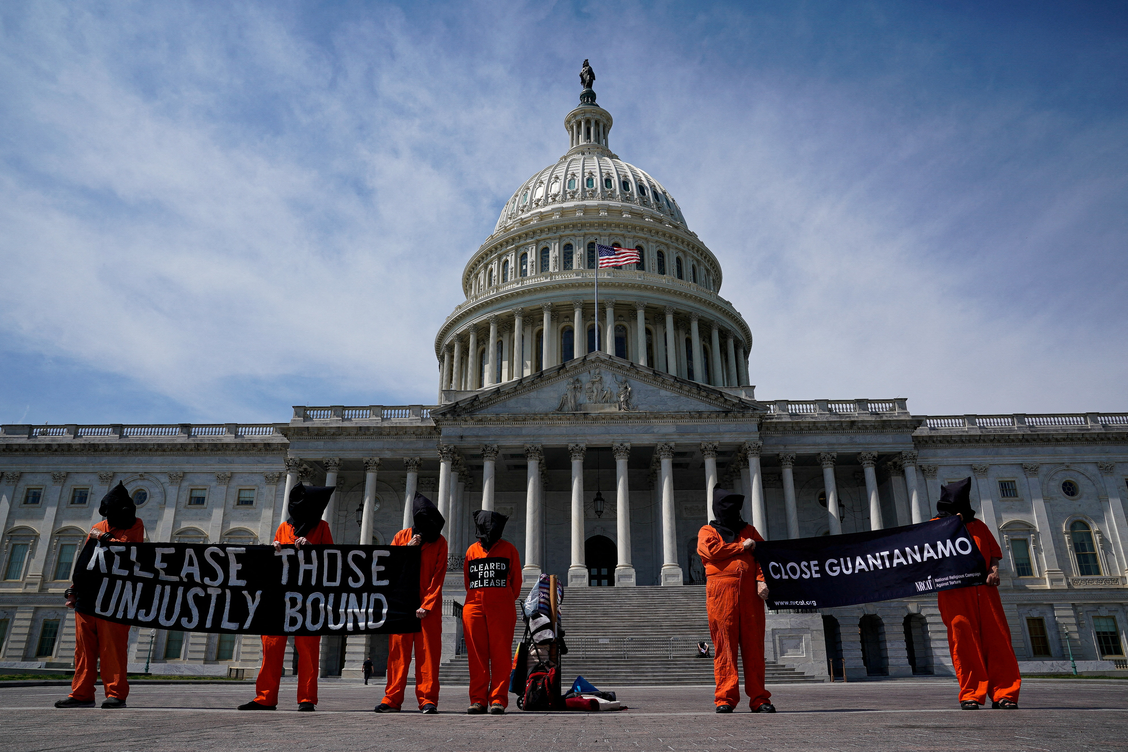 People in orange jumpsuits protest against the U.S. prison at Guantanamo Bay, outside of the U.S. Capitol in Washington