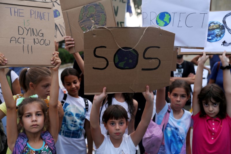Children hold placards during a global climate change strike rally in Nicosia