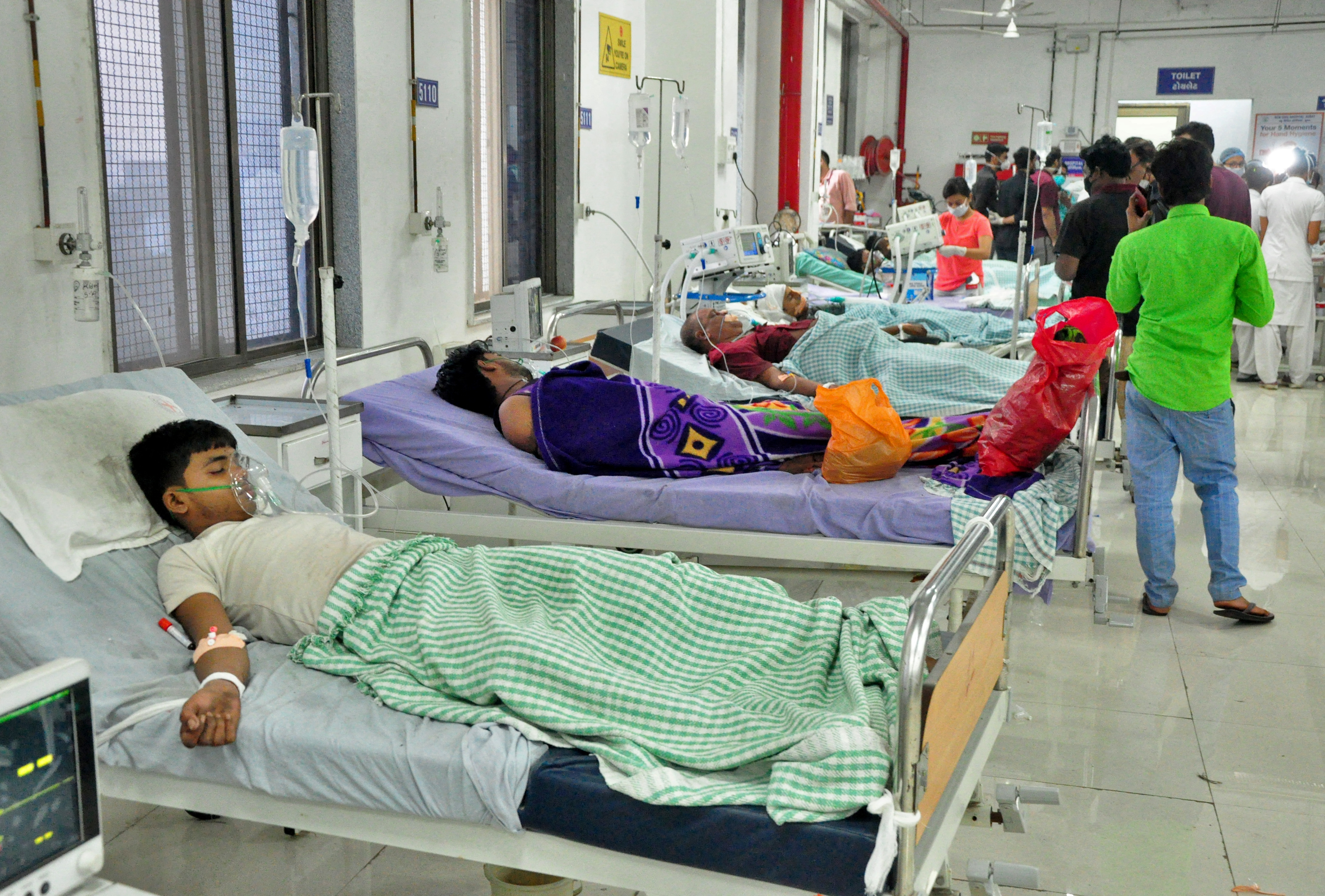 Workers of a dyeing and printing mill receive treatment in a hospital in Surat