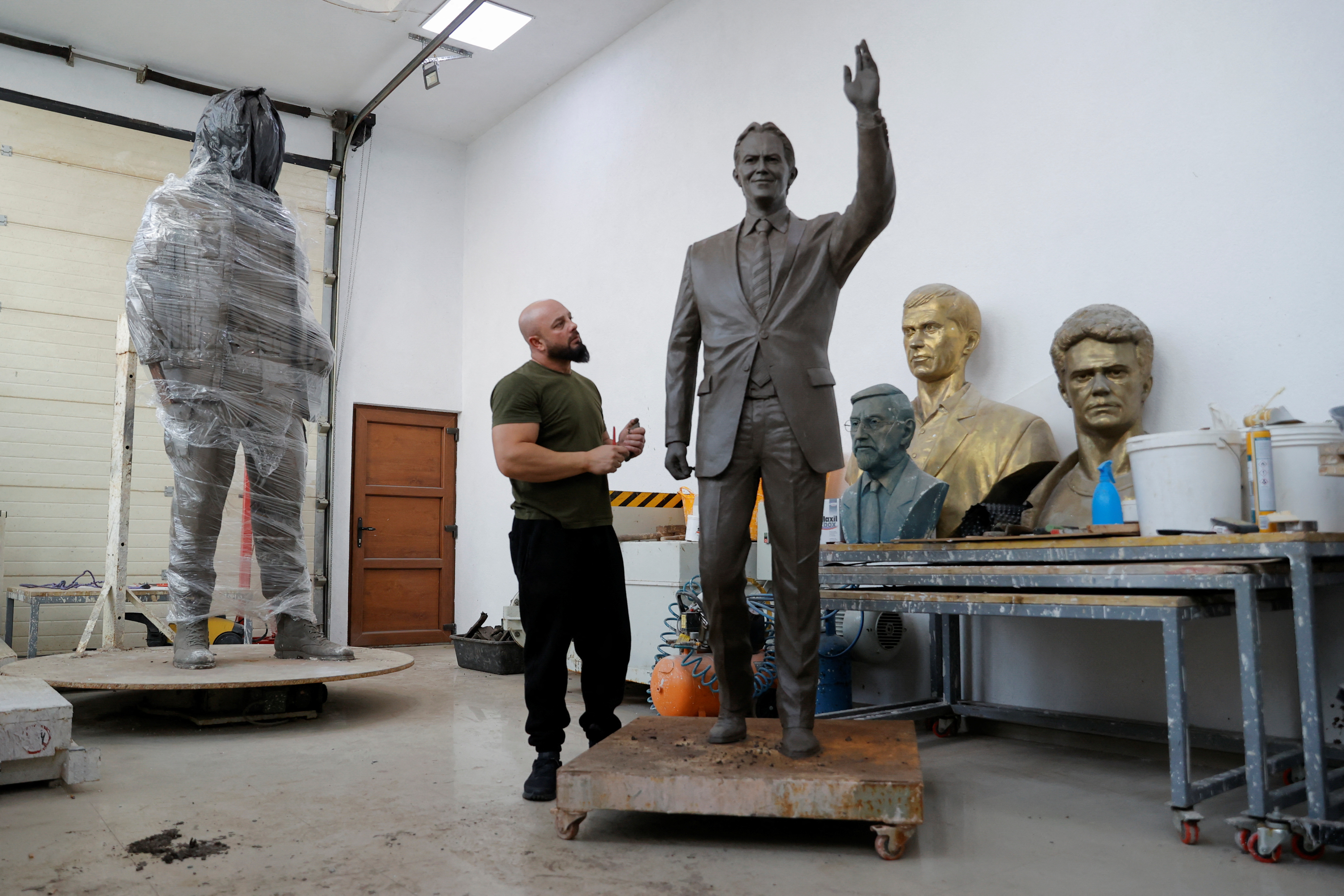 Sculptor Agon Qosa works on a statue of Britain's former prime minister Tony Blair, in Ferizaj
