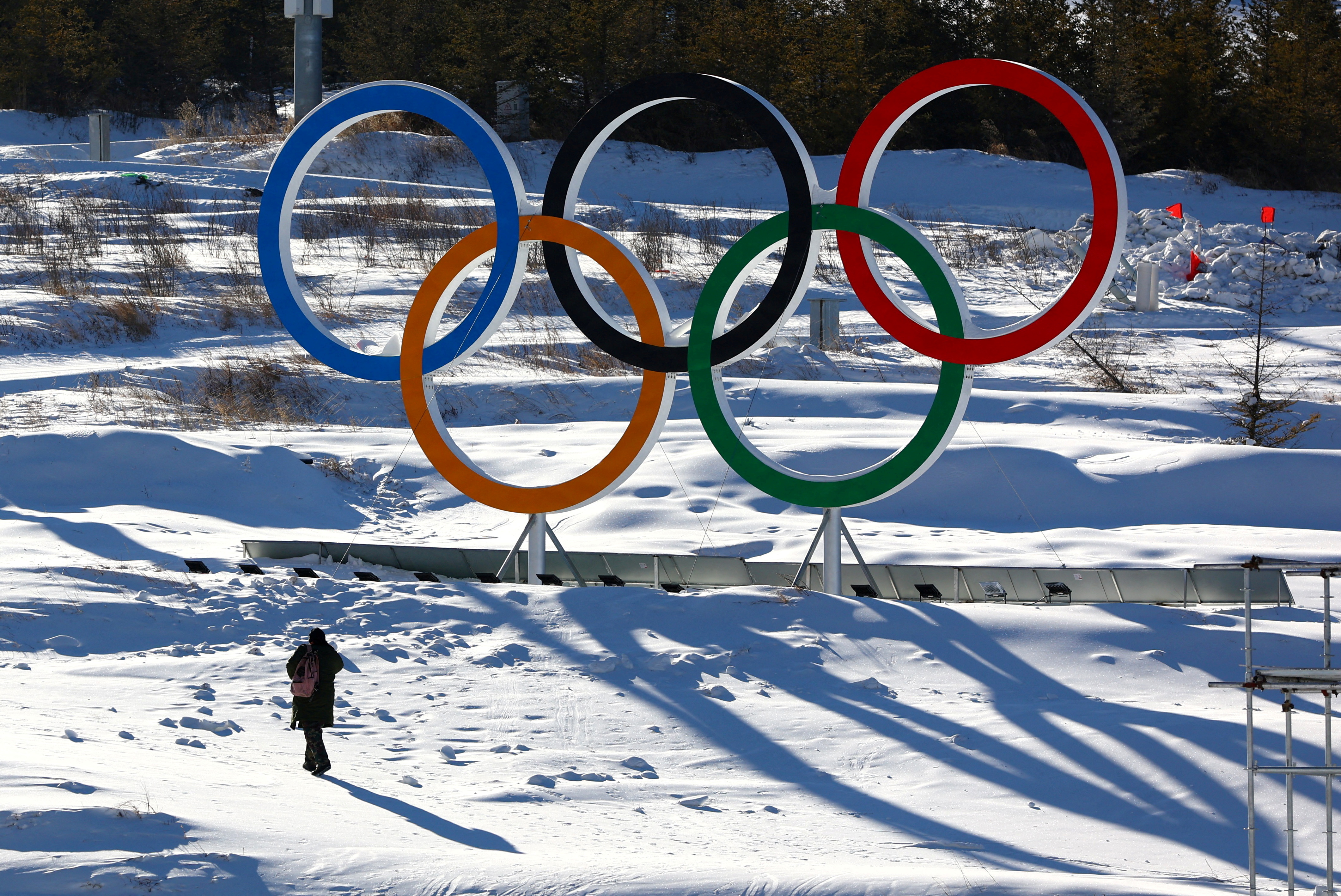 A person walks past the Olympic rings in the Zhangjiakou competition zone ahead of the Beijing 2022 Winter Olympics in Beijing, China January 15, 2022. REUTERS/Pawel Kopczynski