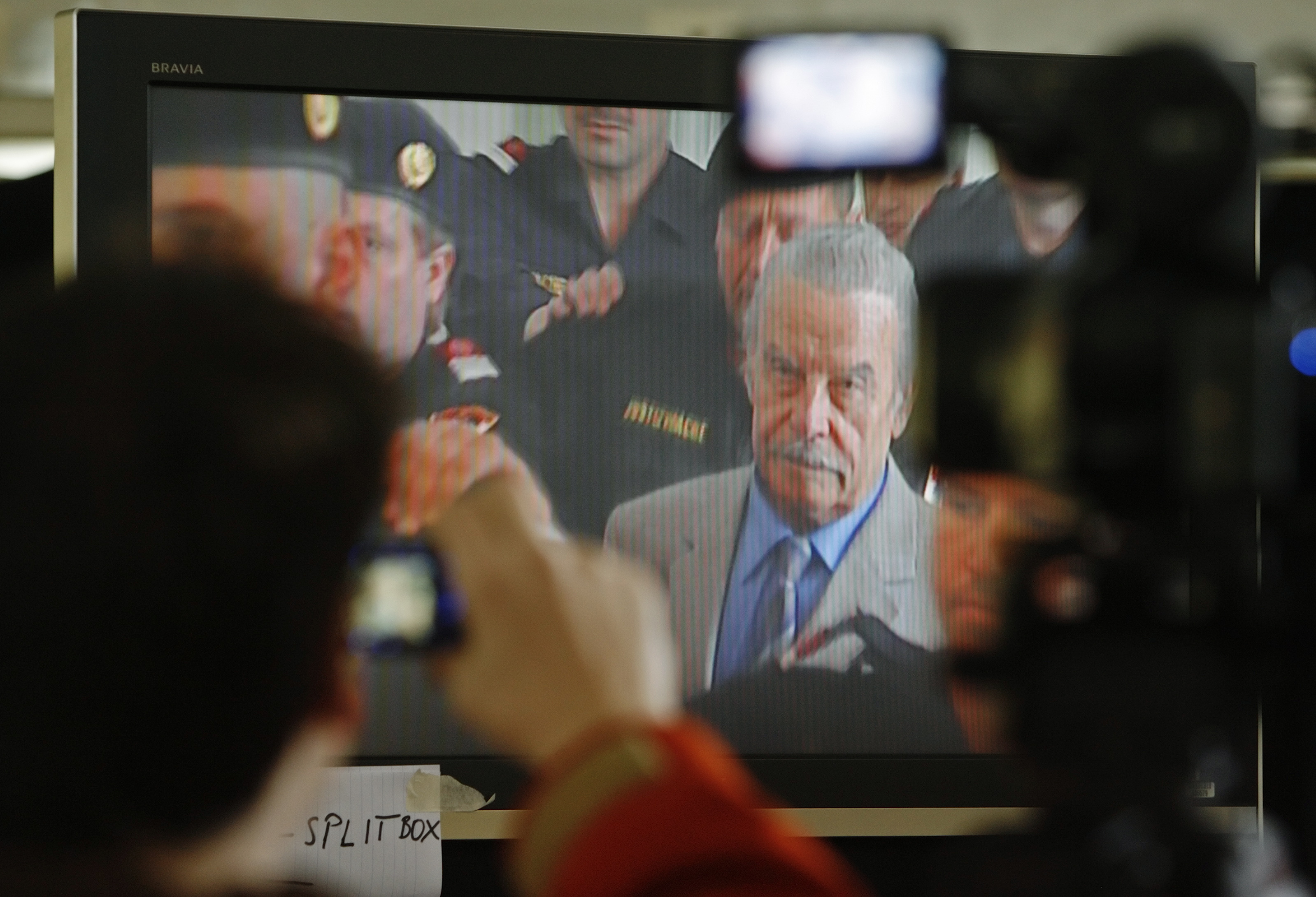 Journalists watch TV screen inside media tent as 73-year-old Austrian Fritzl appears in court on fourth day of his trial in St. Poelten