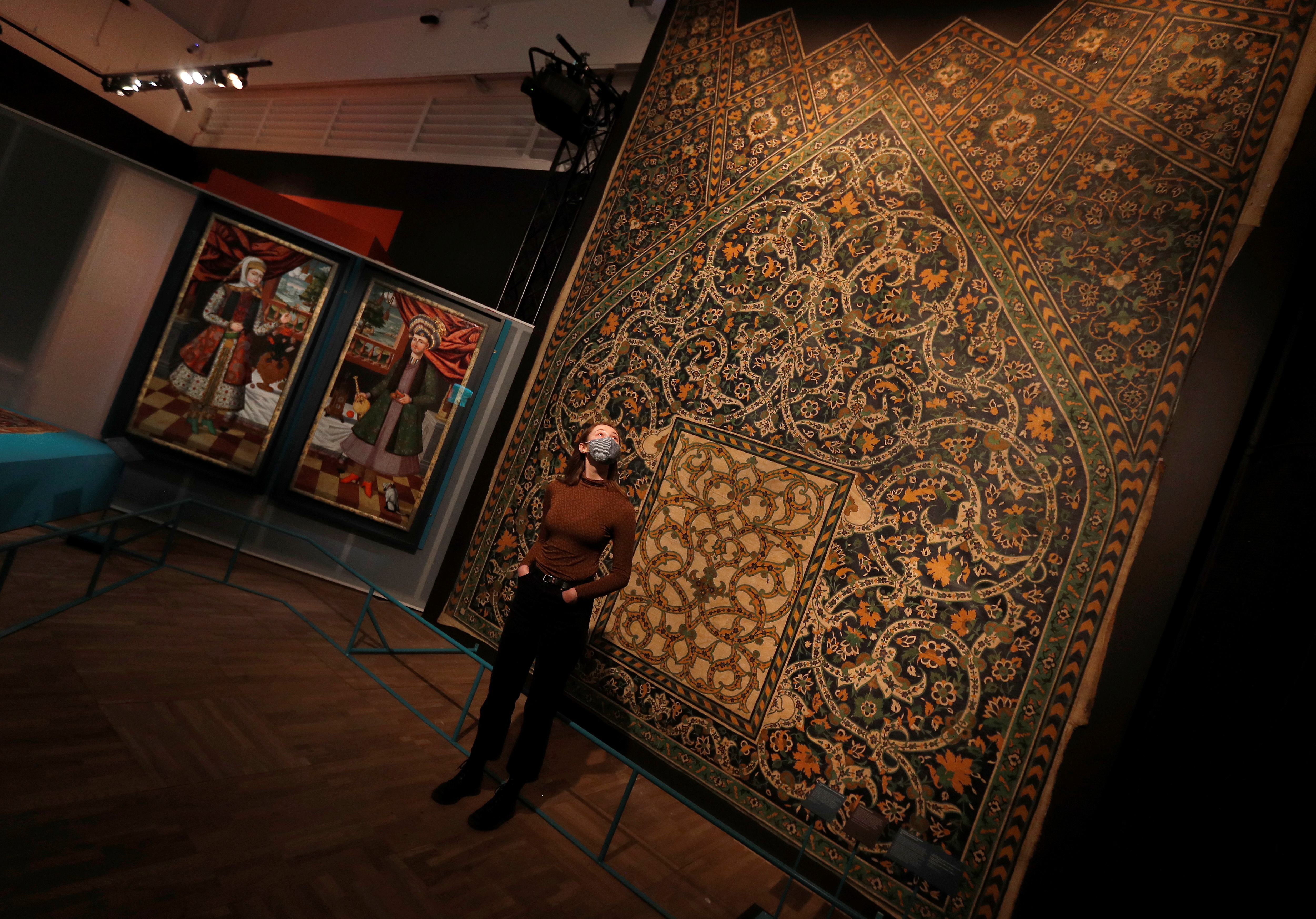 A V&A employee looks up at a full size replica of tiles from Isfahan on display at Epic Iran, an exhibition soon to open at the V&A in London, Britain, May 25, 2021. REUTERS/Peter Nicholls