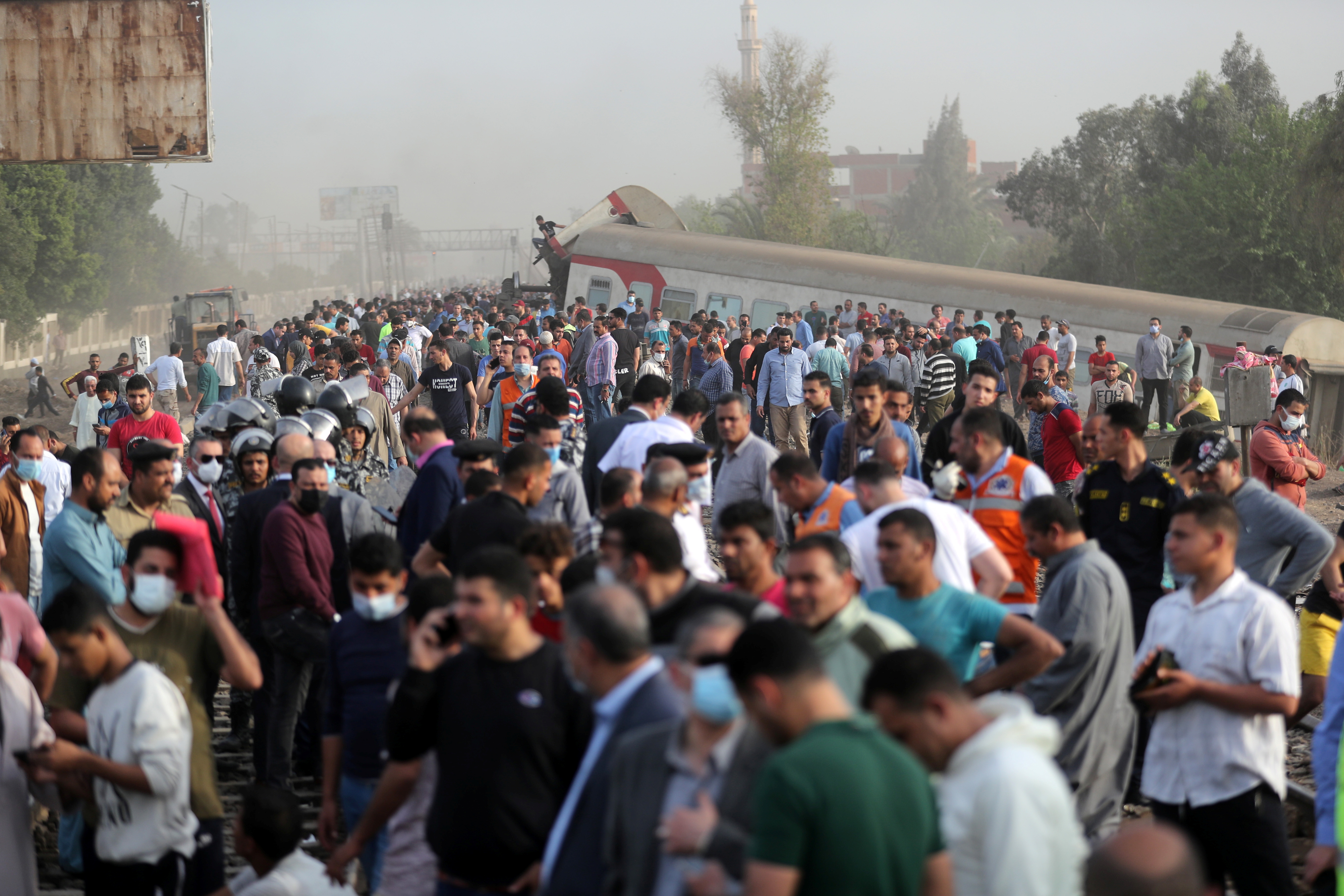 La gente se reúne en el lugar donde descarrilaron los vagones de tren en la provincia de Qalioubia, al norte de El Cairo, Egipto, el 18 de abril de 2021. REUTERS / Mohamed Abd El Ghany