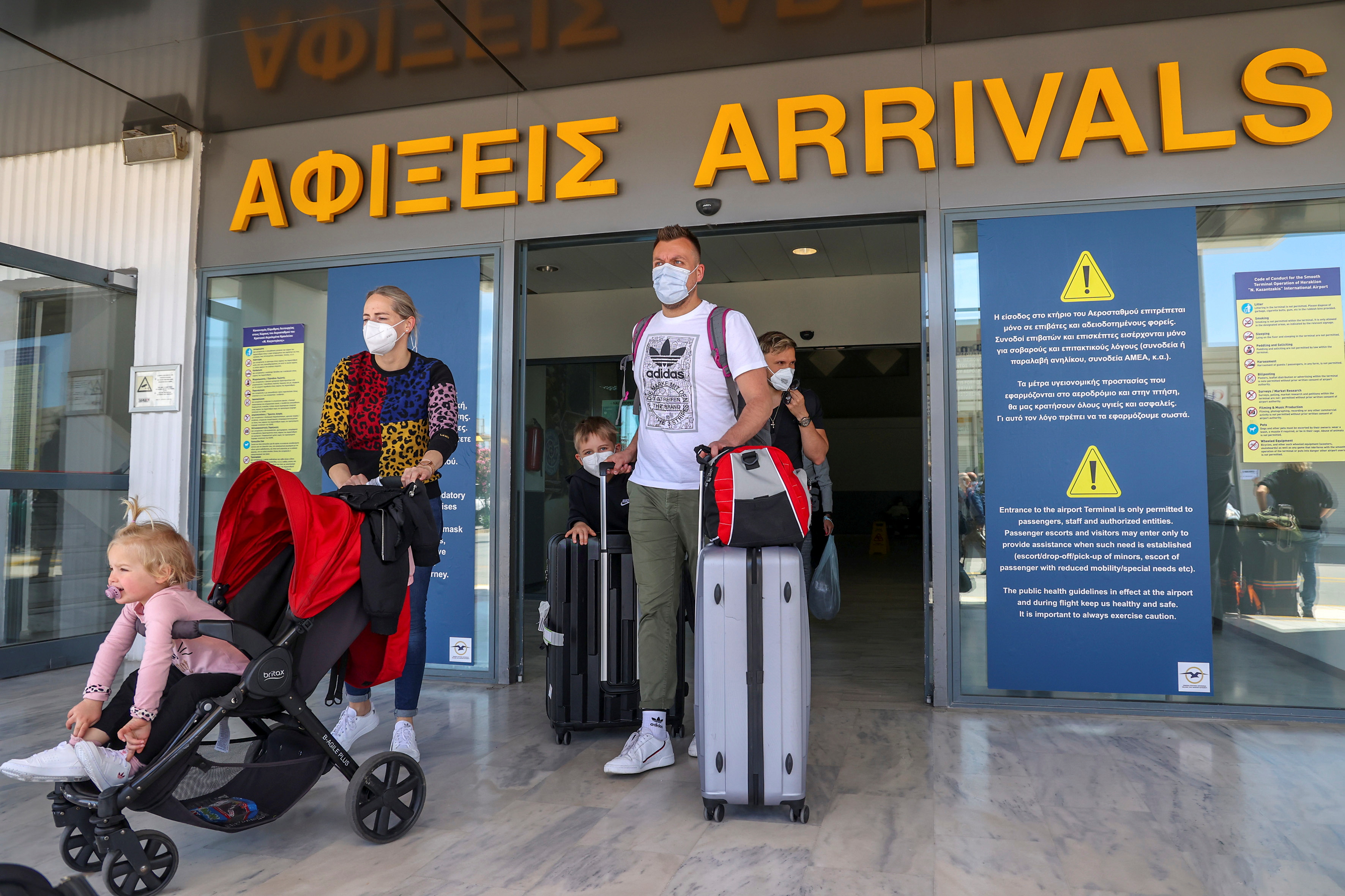 Passengers arriving from Germany and Switzerland exit the terminal of the Heraklion airport, as the country's tourism season officially opens, on the island of Crete, Greece, May 15, 2021. REUTERS/Stefanos Rapanis/File Photo
