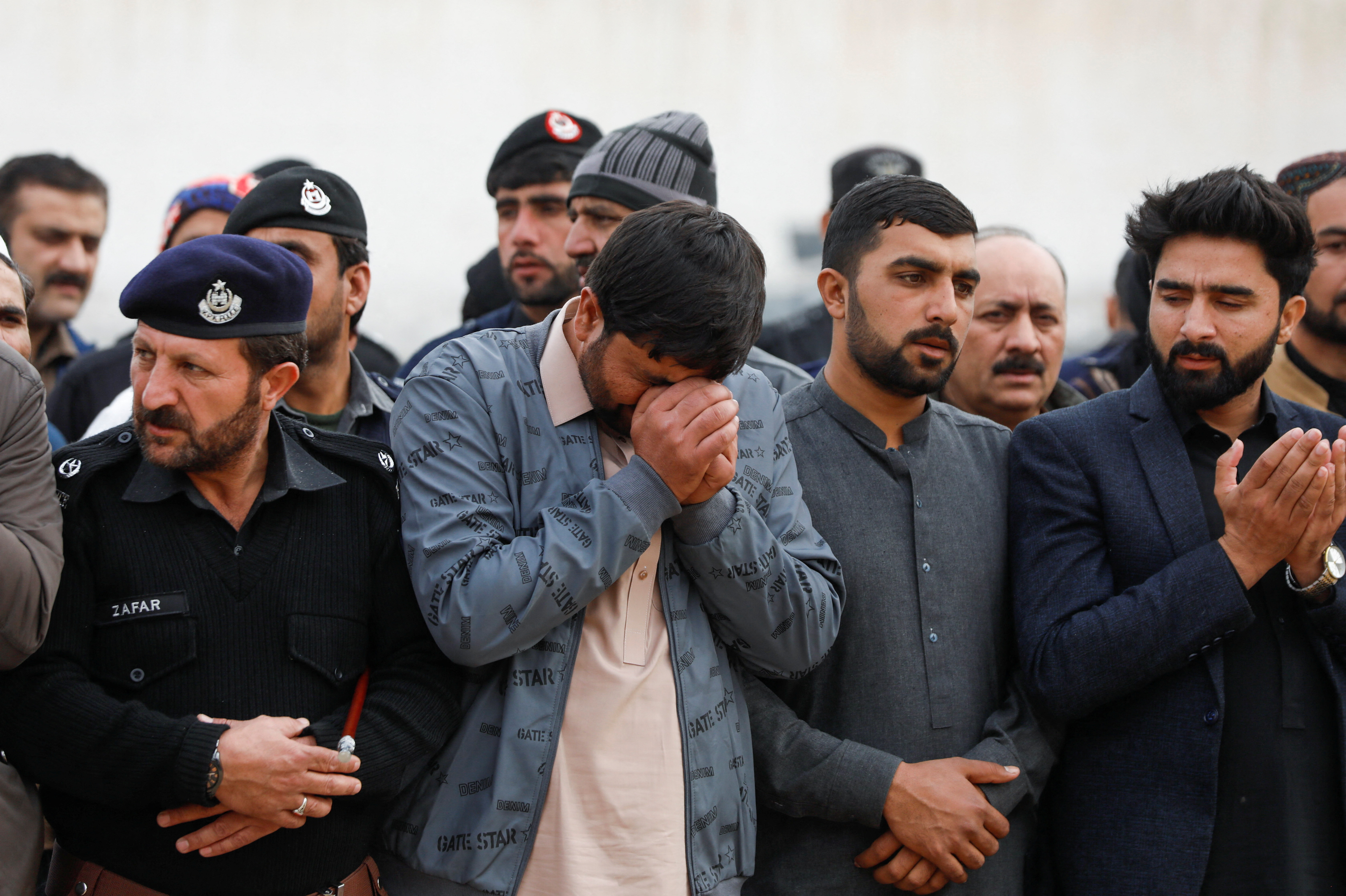 Brother of Zareef Khan, who along with others was killed after a suicide blast in a mosque, reacts during his funeral in Peshawar