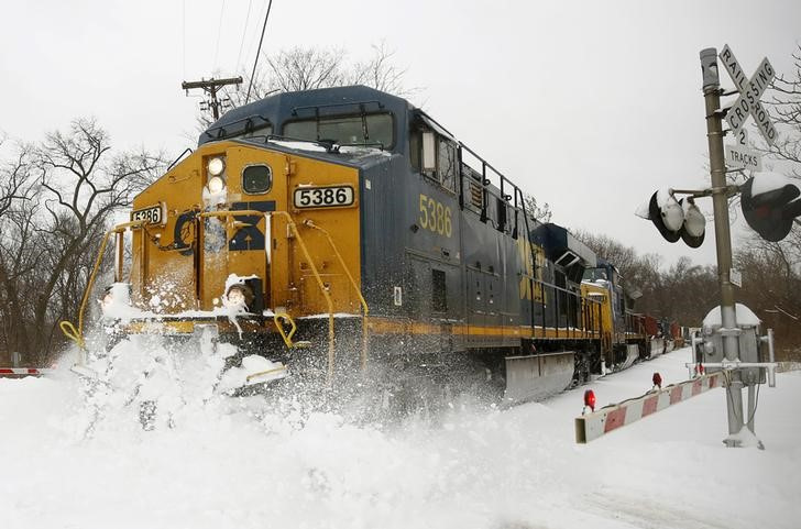 A CSX freight train blasts through high snow at a crossing in Silver Spring