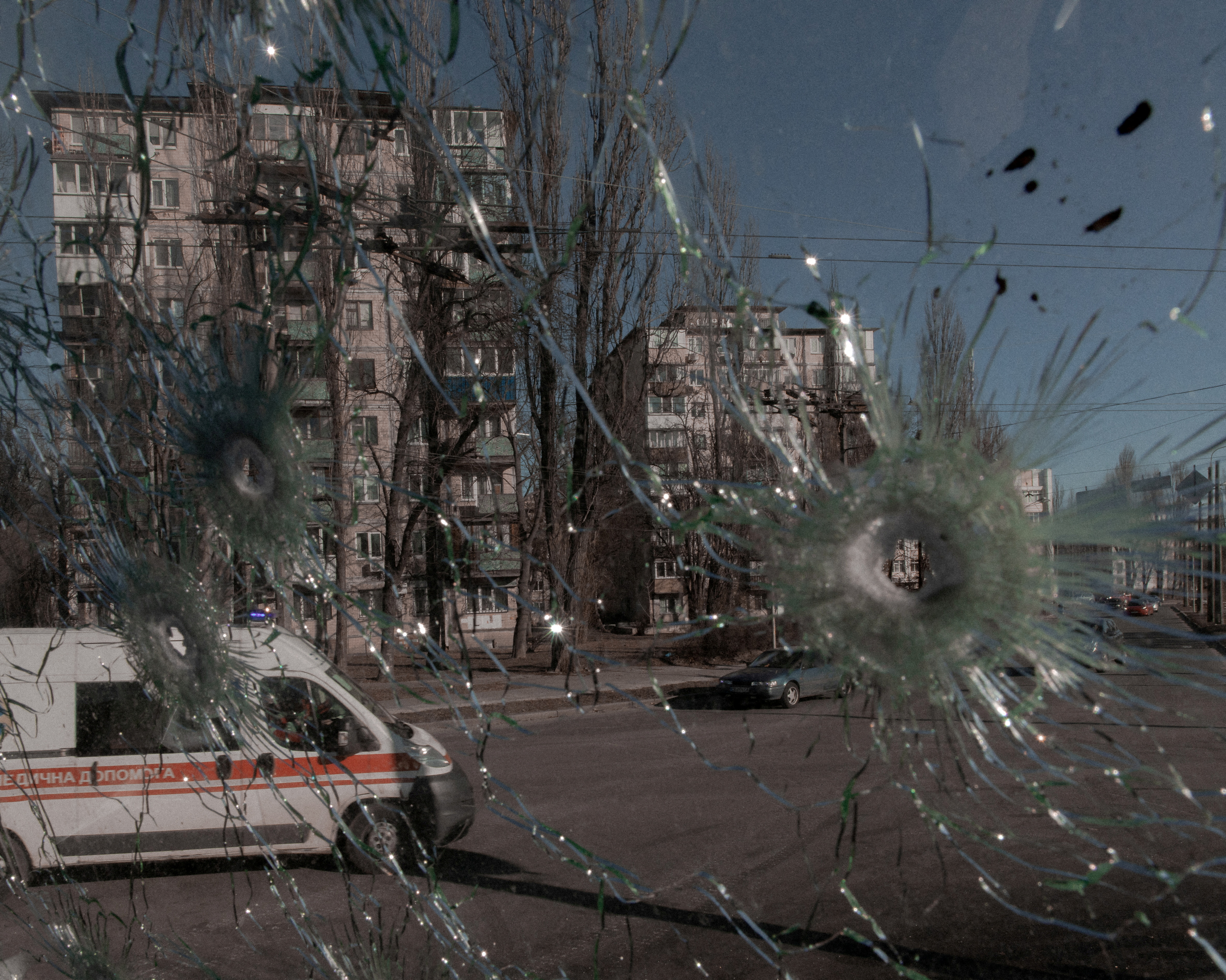 Un'ambulanza è vista attraverso il finestrino danneggiato di un veicolo colpito da proiettili, mentre l'invasione russa dell'Ucraina continua, a Kiev, Ucraina, 28 febbraio 2022. Jedrzej Nowicki/Agencja Wyborcza.pl via REUTERS