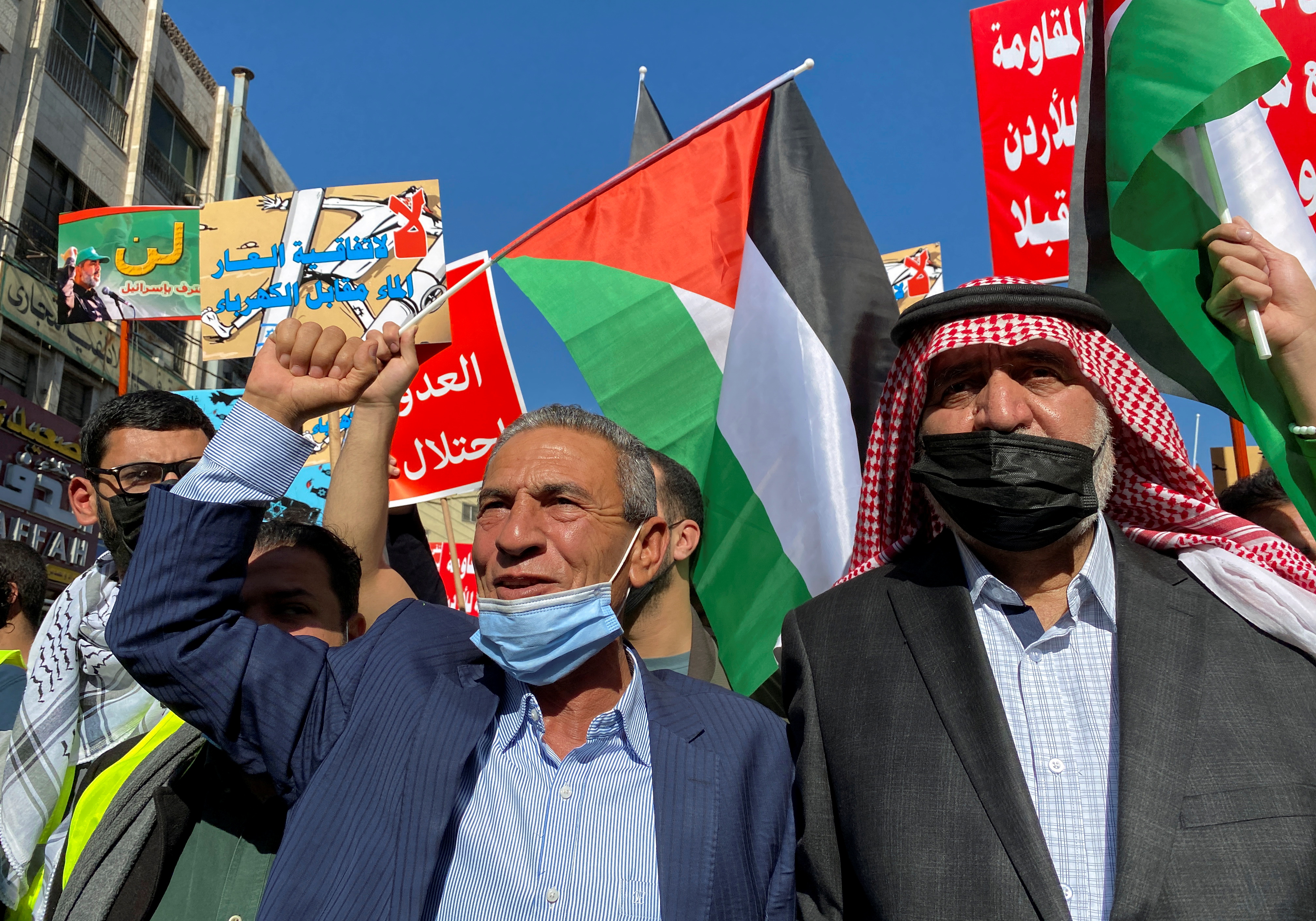 Jordanians carry flags and placards as they demonstrate against the declaration of intent for water-for-energy deal signed by Israel, Jordan and the UAE, in Amman, Jordan November 26, 2021. REUTERS/Muath Freij