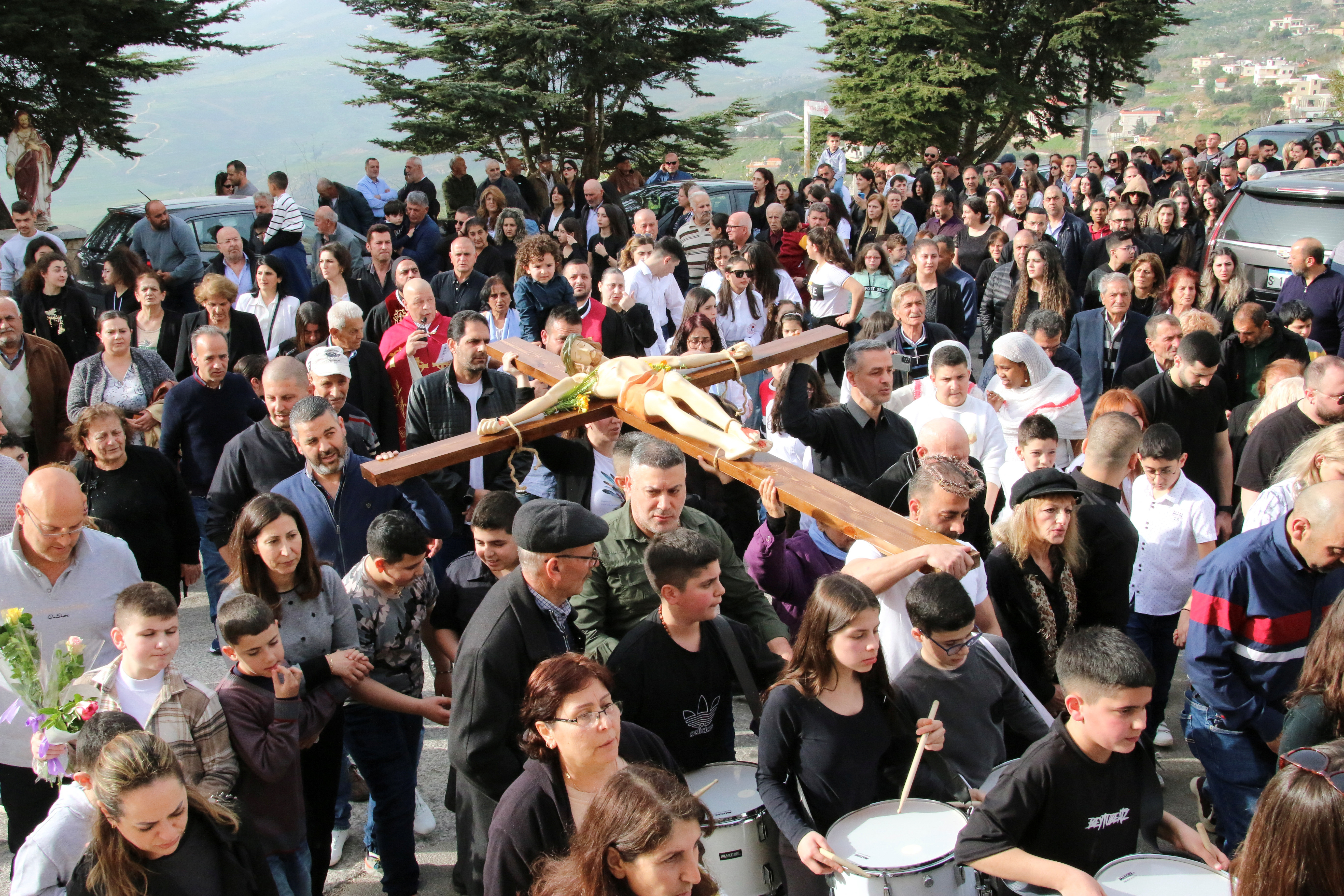 Christian worshippers take part in the Good Friday procession as they carry a cross with a Jesus Christ statue, in the town of Klayaa