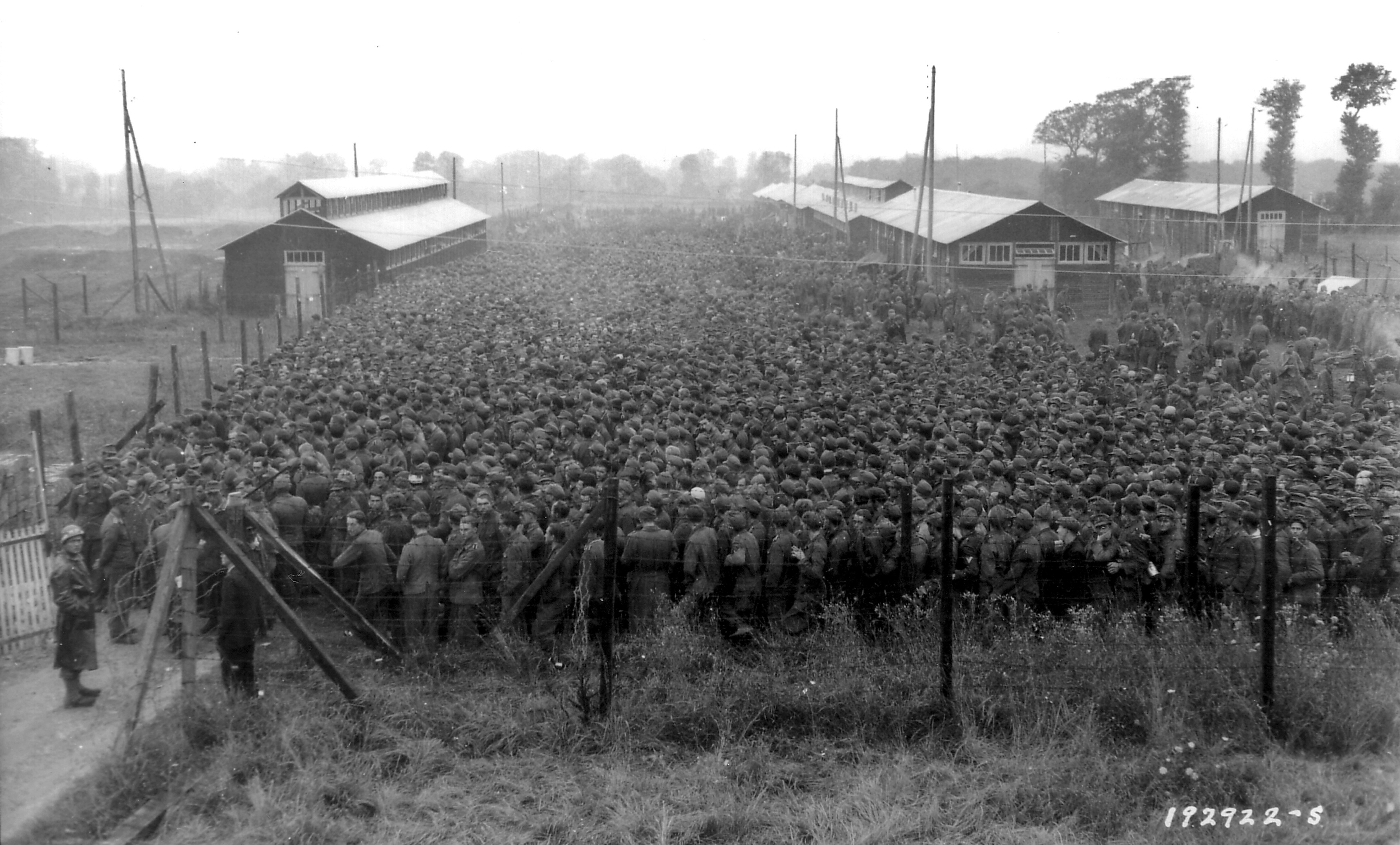 Handout photo of German POWs being guarded by U.S. troops at a camp in Nonant-le-Pin