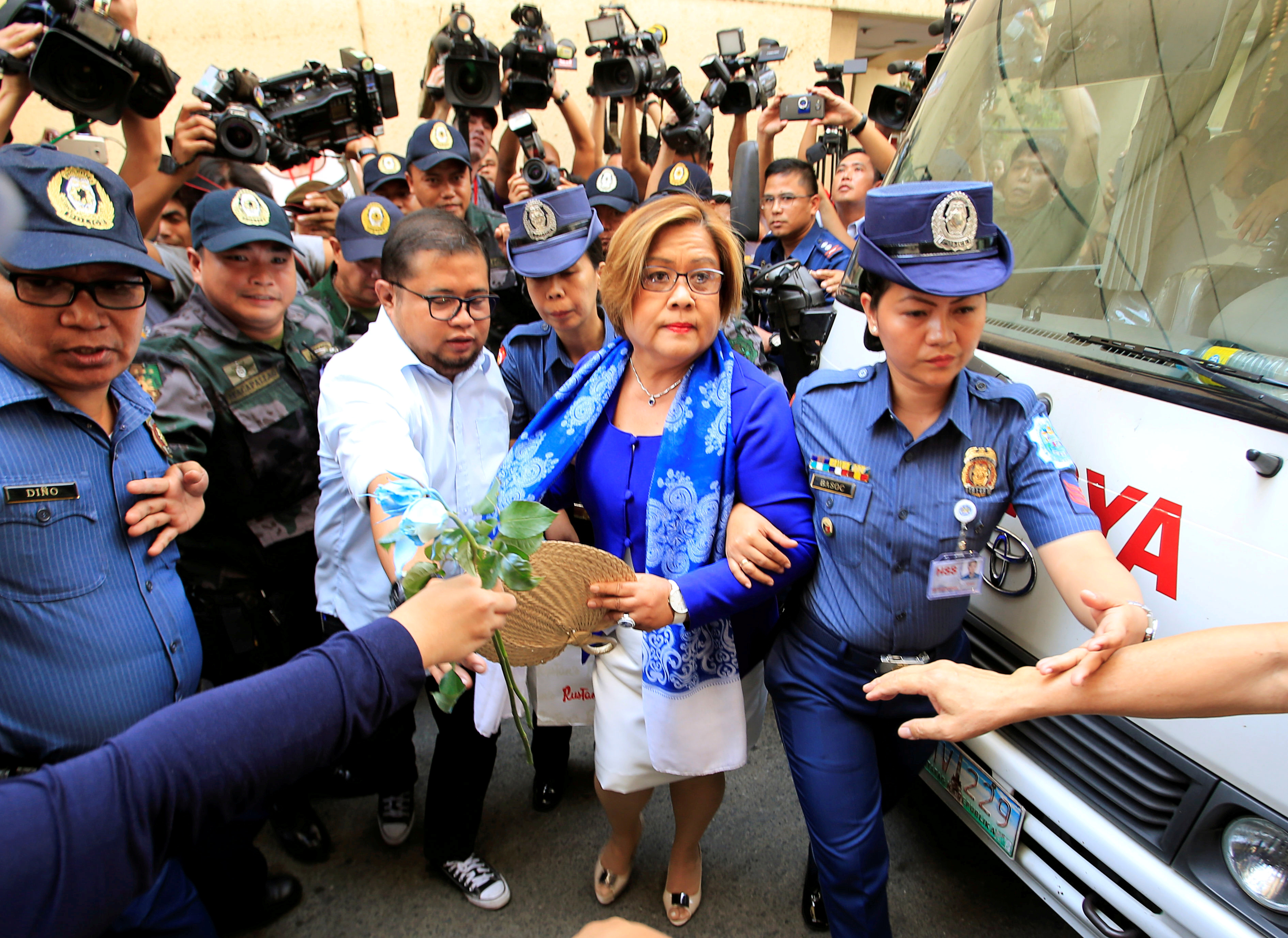 Philippine police escort Leila de Lima, a senator detained on drug charges, on her way to a local court to face an obstruction of justice complaint in Quezon city, metro Manila