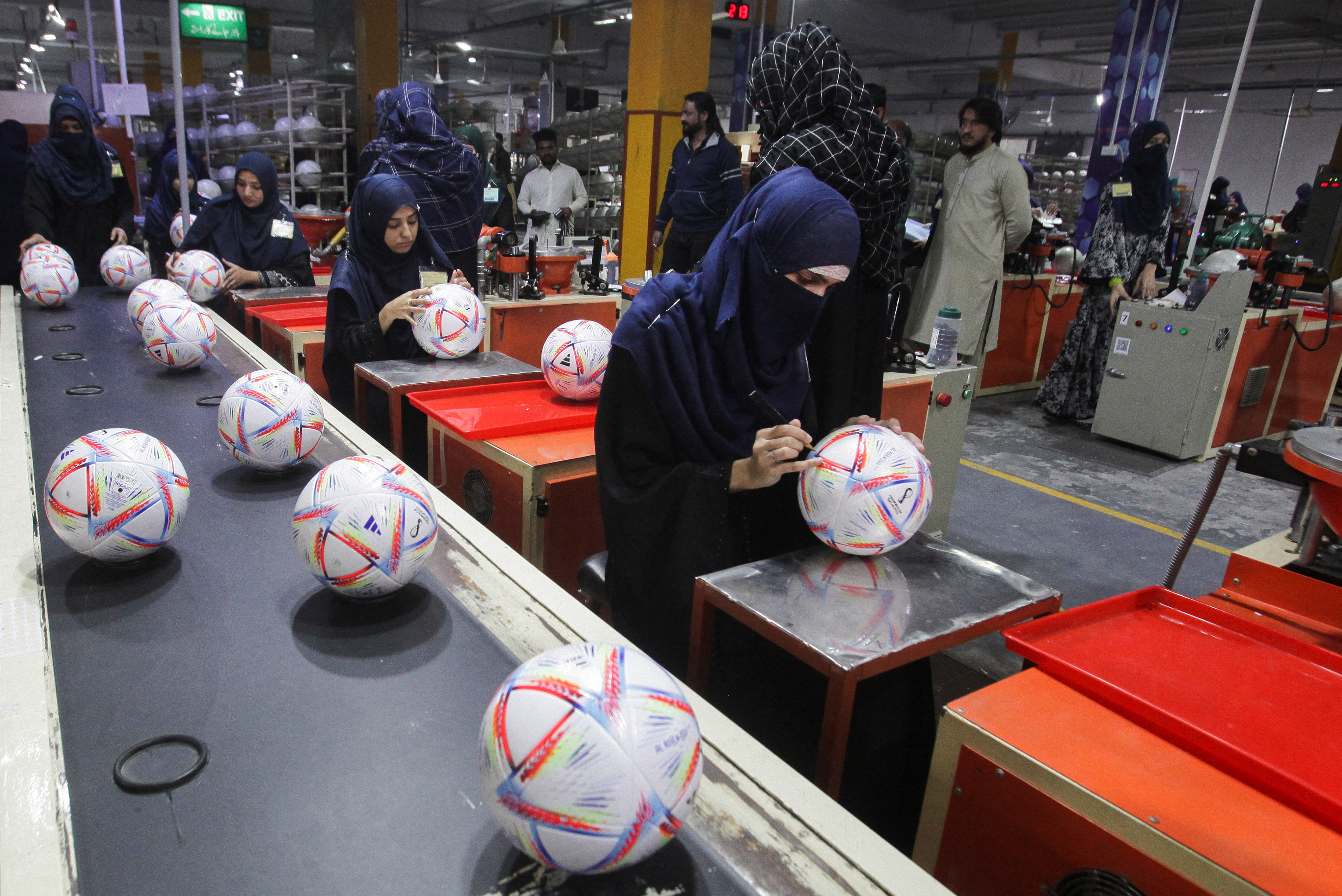 Workers conduct the final check of balls inside the soccer ball factory in Sialkot