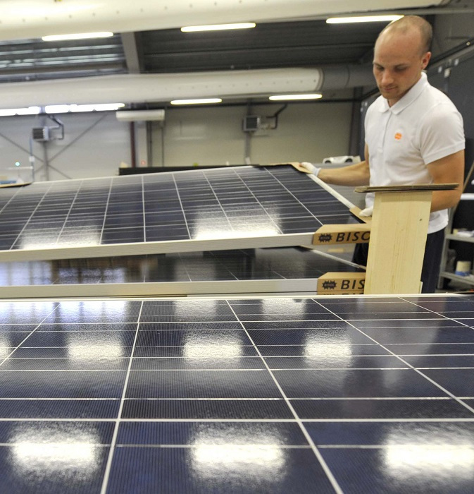 Workers carry photovoltaic modules at the production plant of Slovenian company Bisol in Latkova Vas