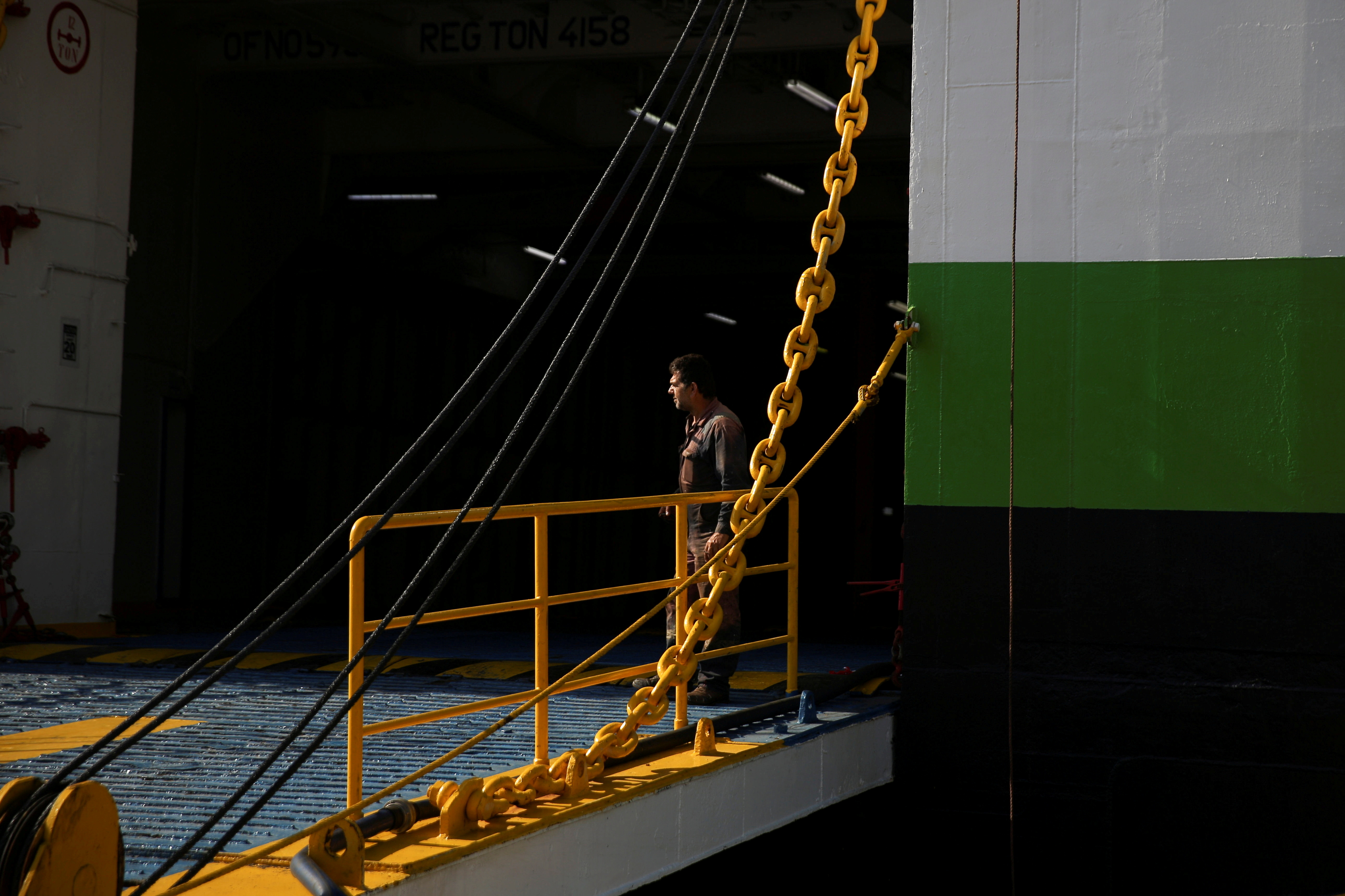 A seaman stands at the entrance of a moored passenger ferry during a 24-hour general strike at the port of Piraeus