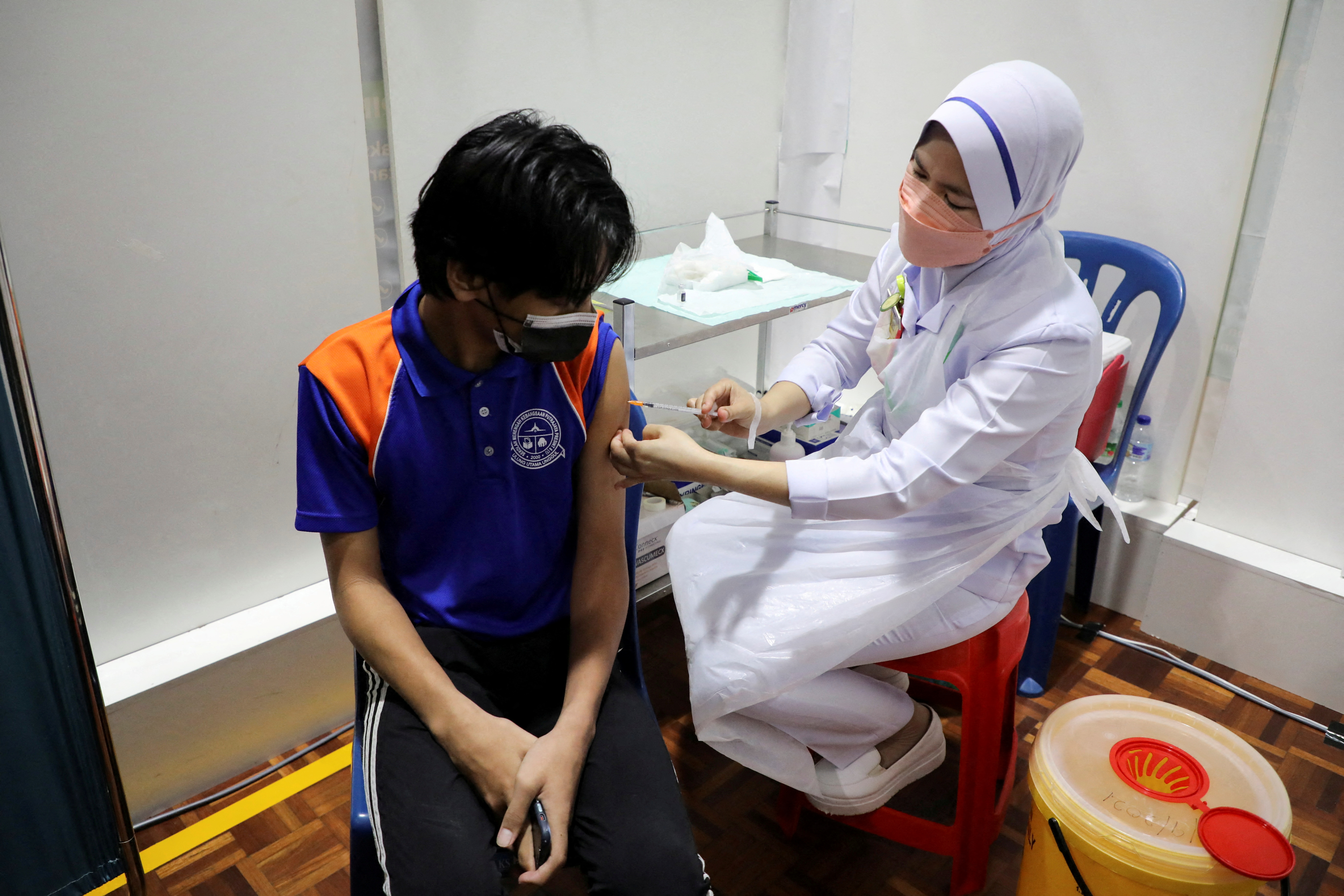 Secondary school student receives a dose of the Pfizer vaccine against the coronavirus disease (COVID-19) at a school, in Putrajaya