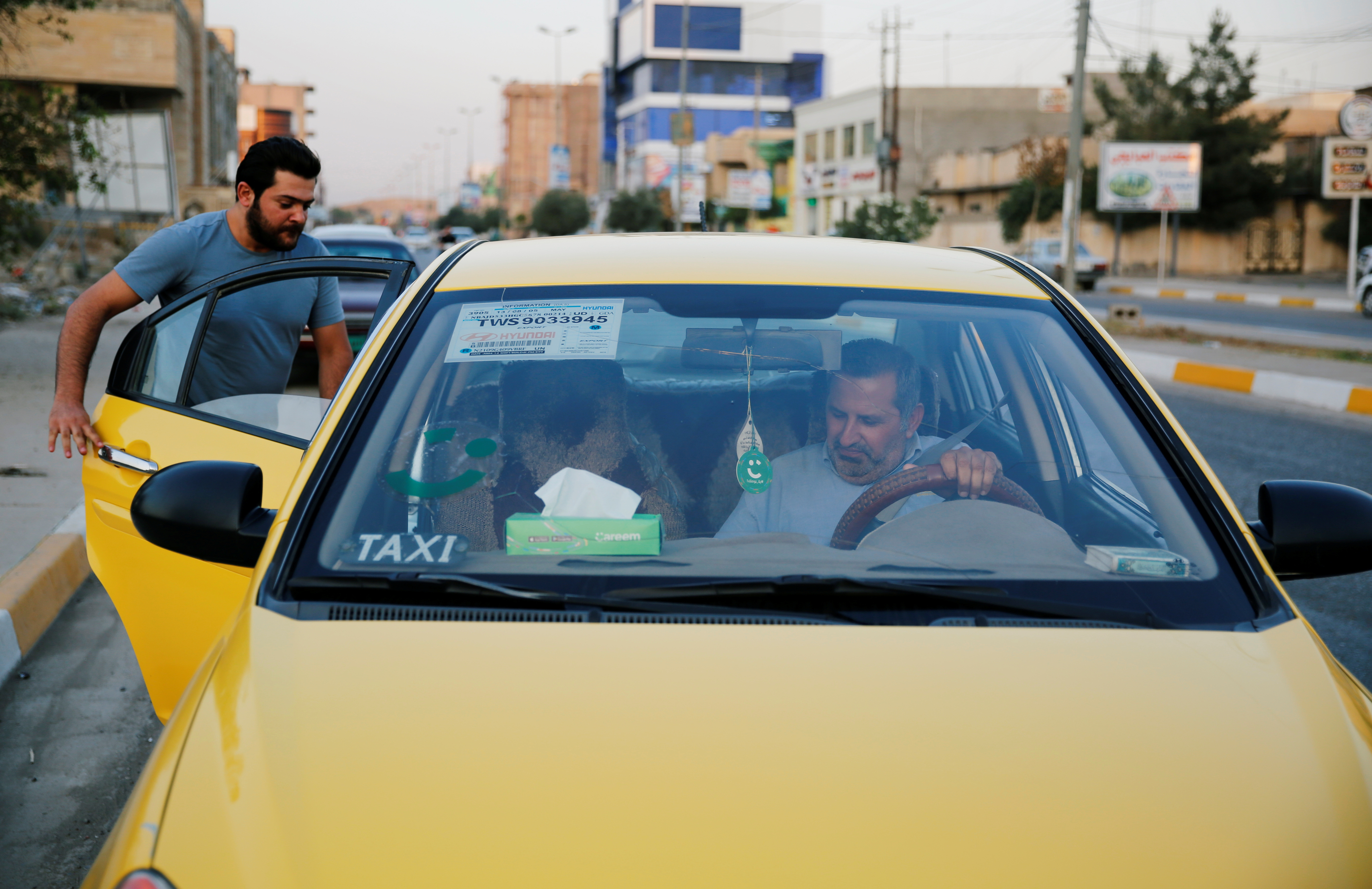 A customer enters one of Careem cars in Mosul