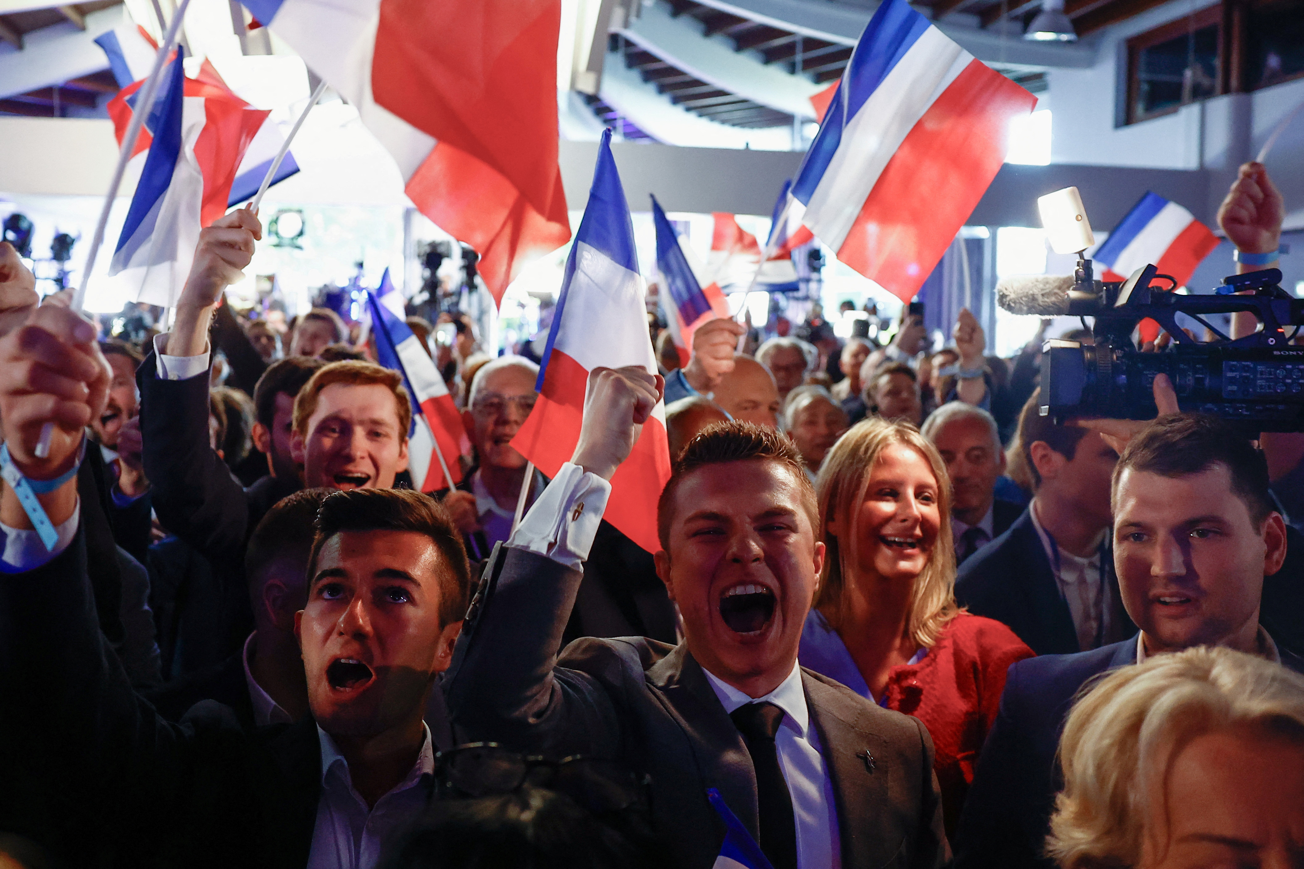 far-right National Rally (Rassemblement National - RN) party members react after the polls closed during the European Parliament elections, in Paris