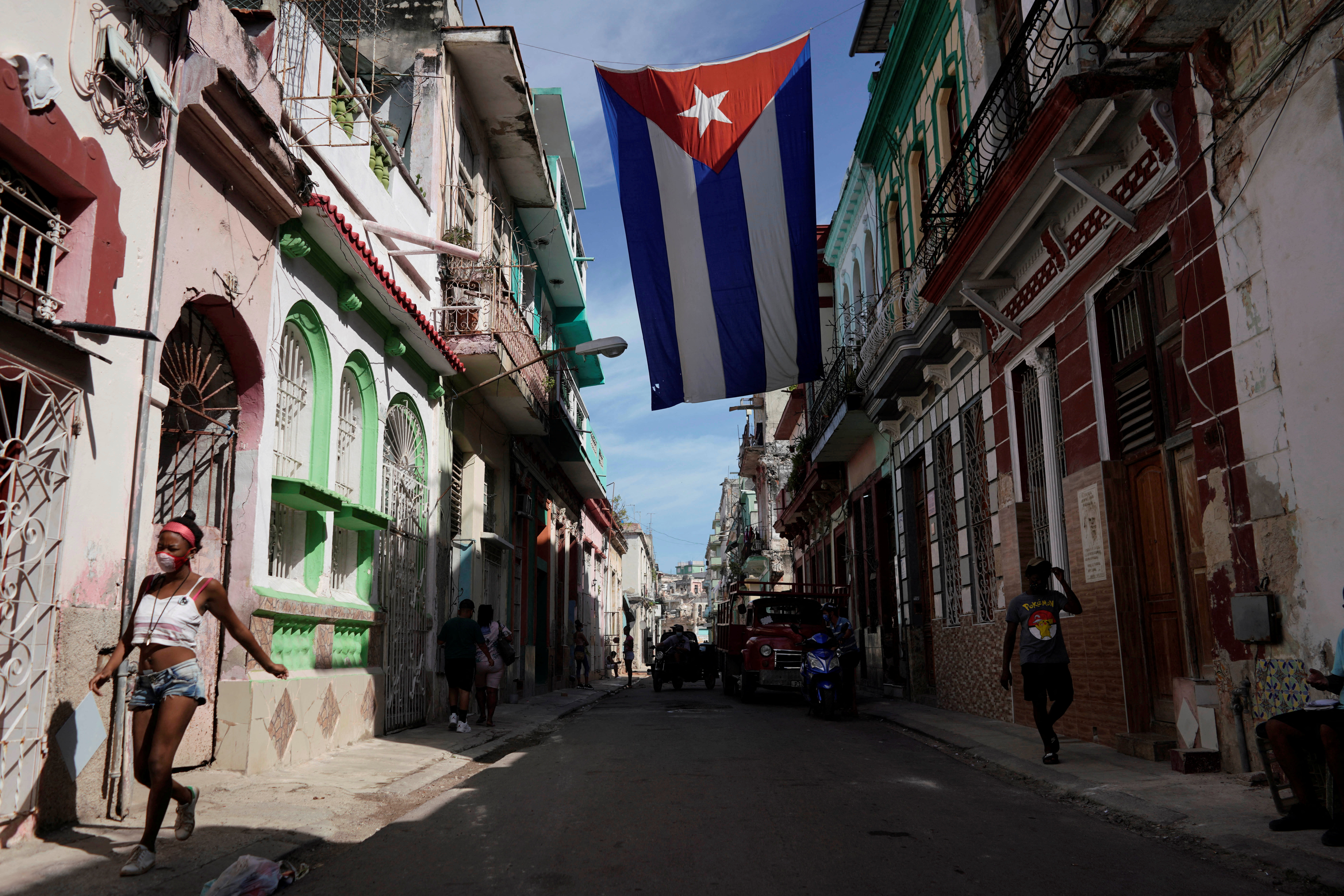 People walk under a Cuban flag in downtown Havana