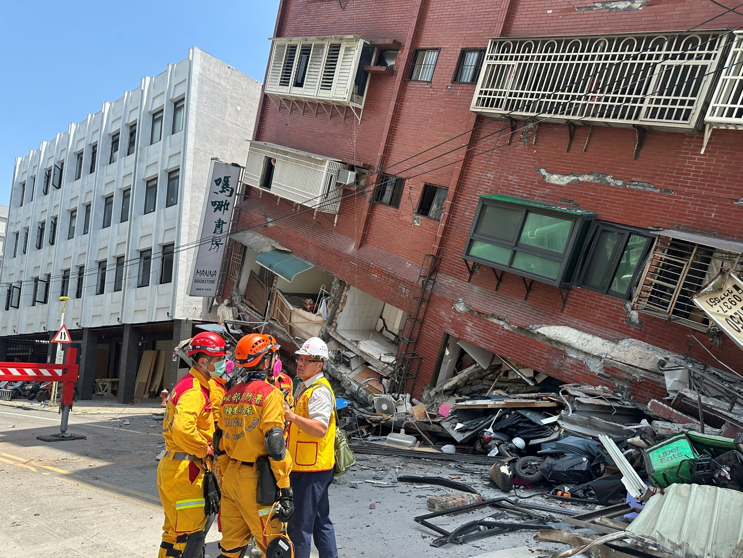 अग्निशामक उस स्थान पर काम करते हैं जहां भूकंप के बाद एक इमारत ढह गई थी, Hualien में