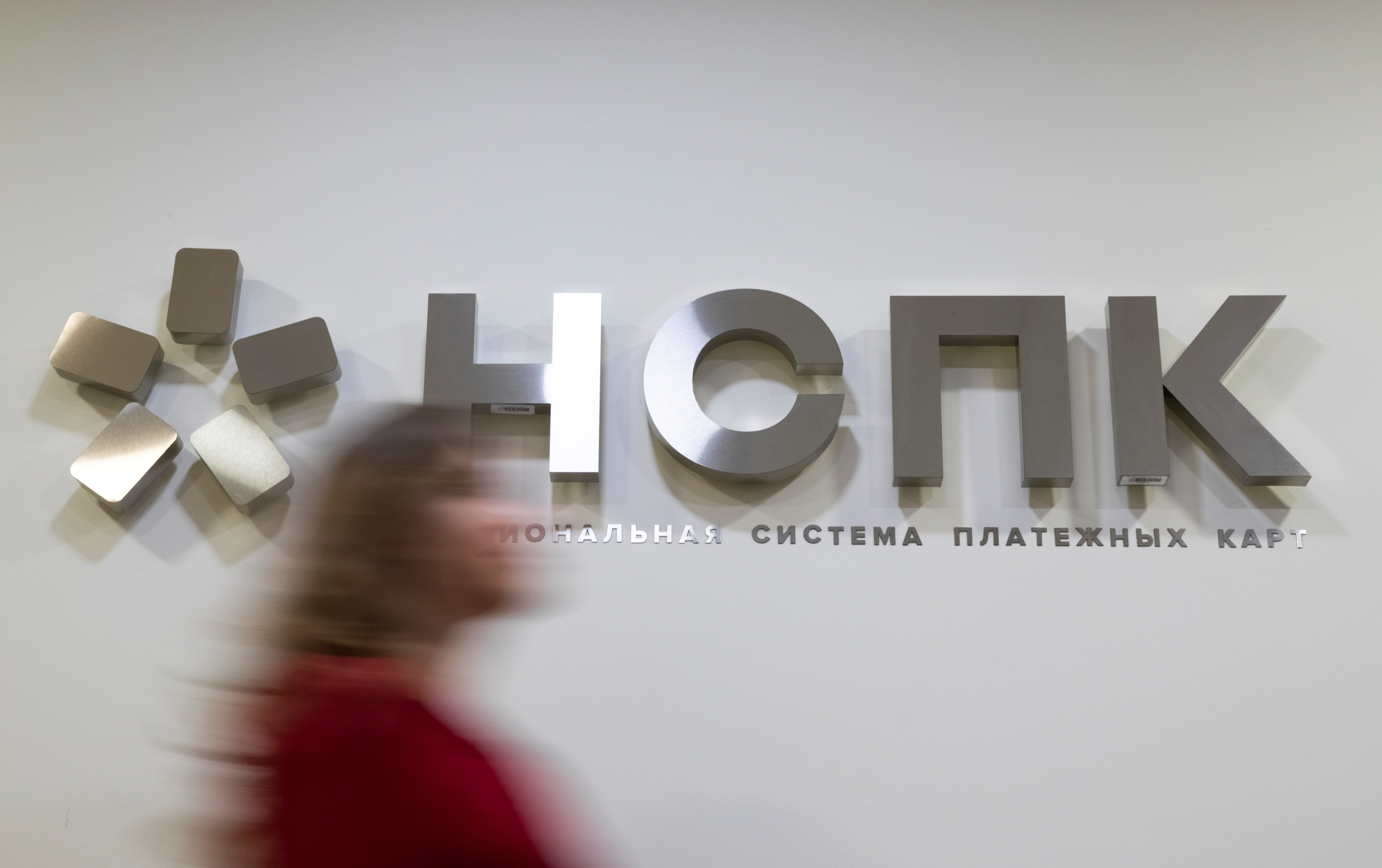 A woman passes in front of a NSPK signage at the company's office in Moscow