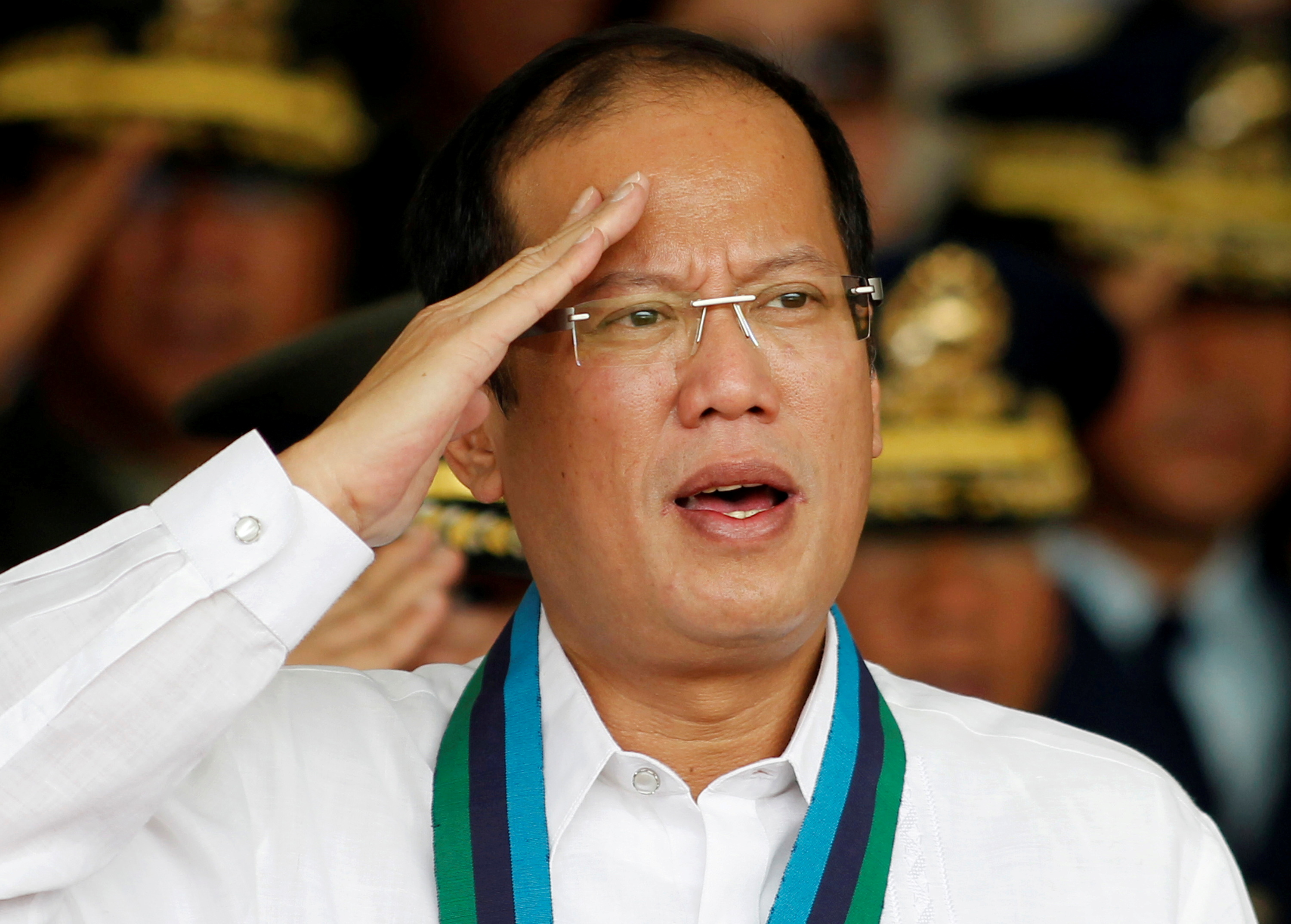 FILE PHOTO - Philippine President Aquino salutes while singing the national anthem during a handover ceremony for the new armed forces chief at Camp Aguinaldo