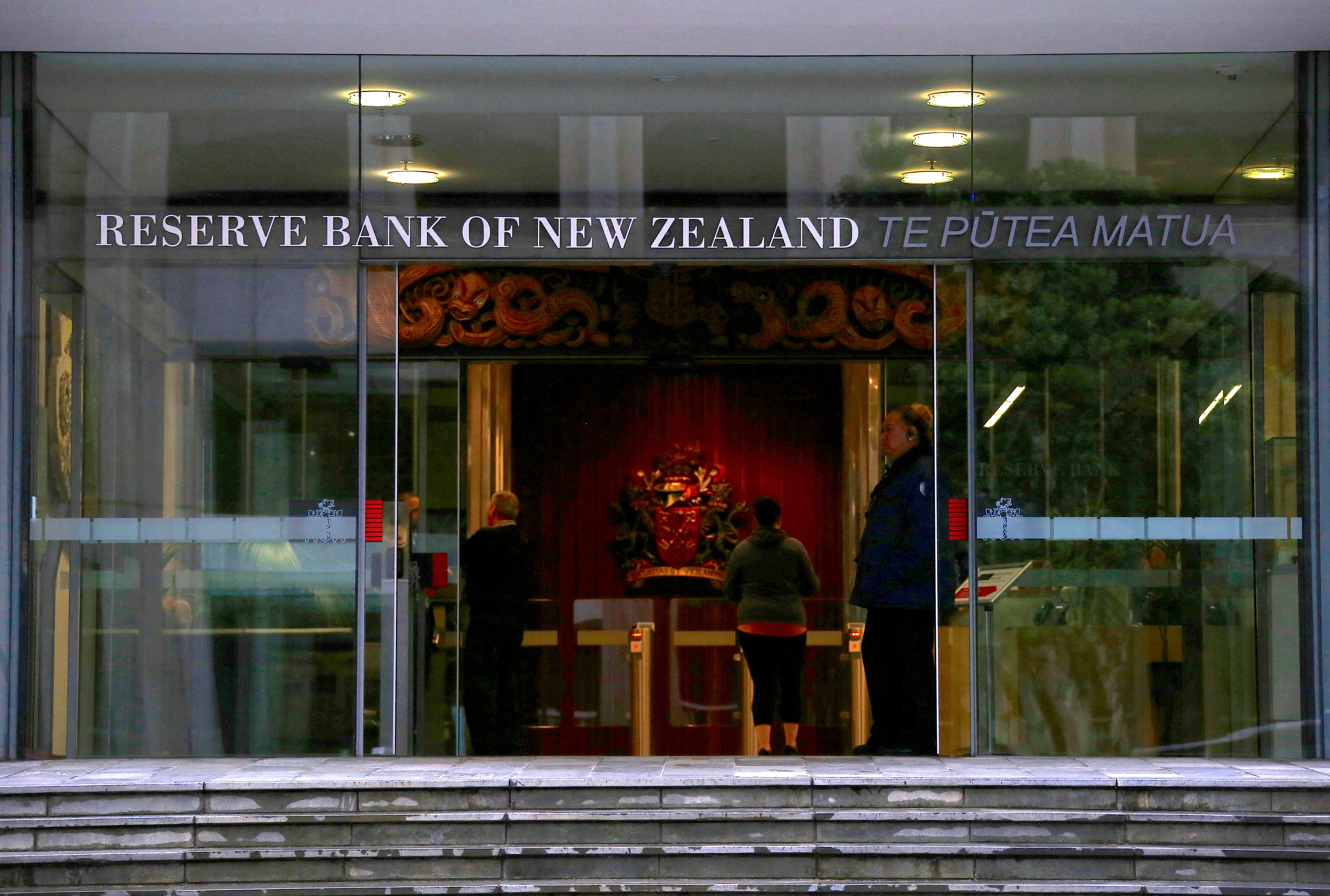 A security guard stands in the main entrance to the Reserve Bank of New Zealand located in central Wellington, New Zealand