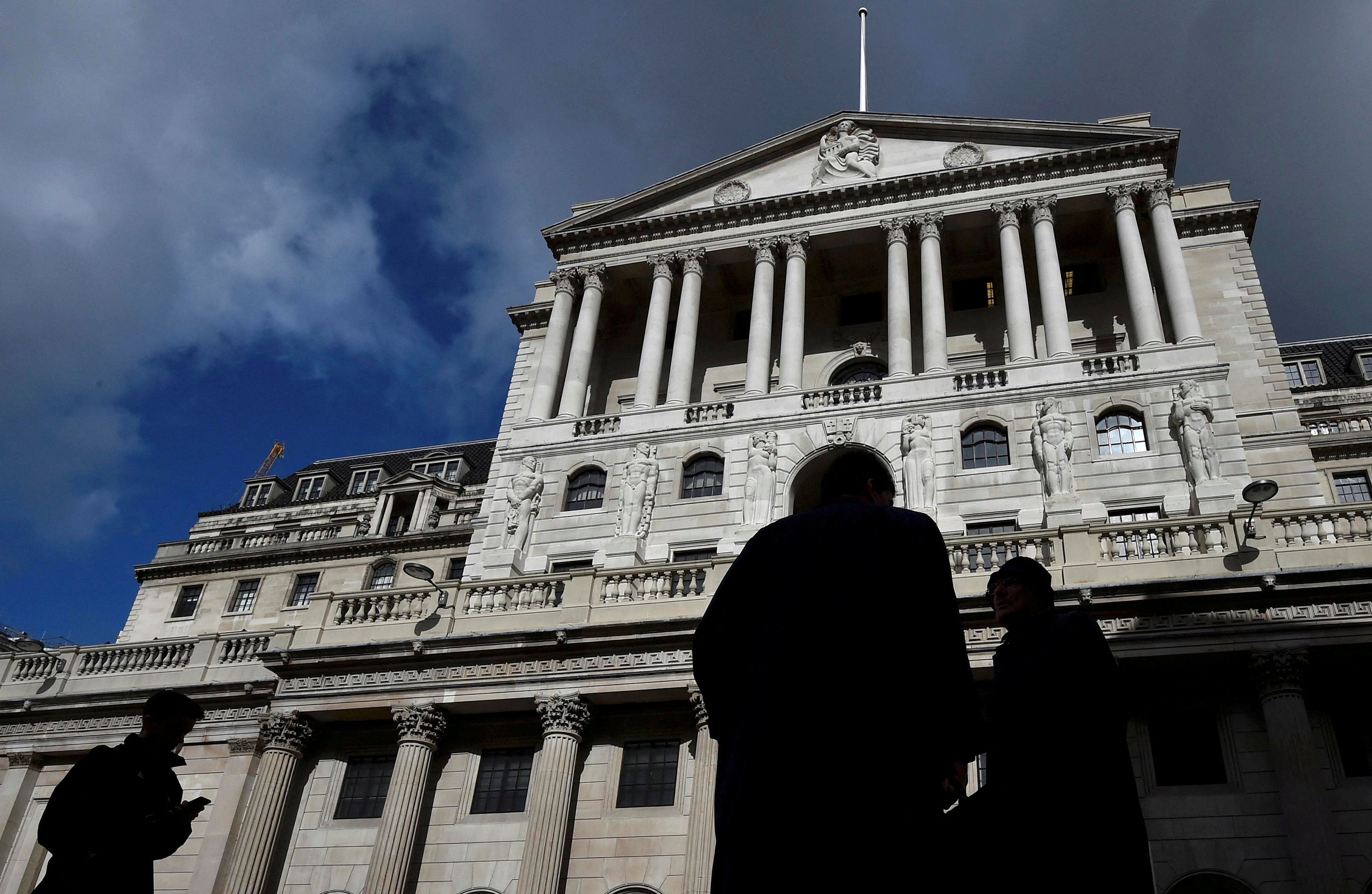 City workers walk past the Bank of England in the City of London, Britain