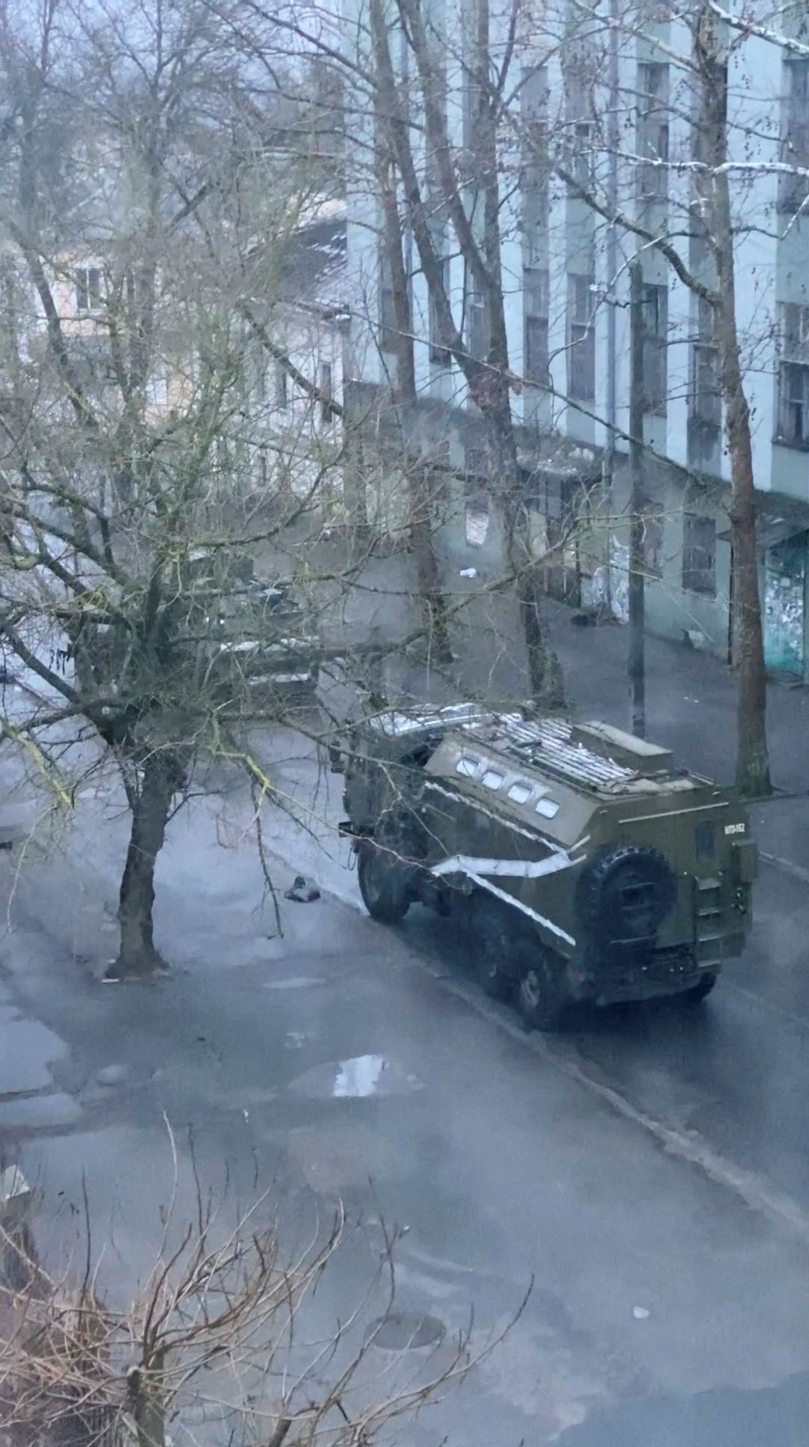 A military truck and tank are seen on a street of Kherson