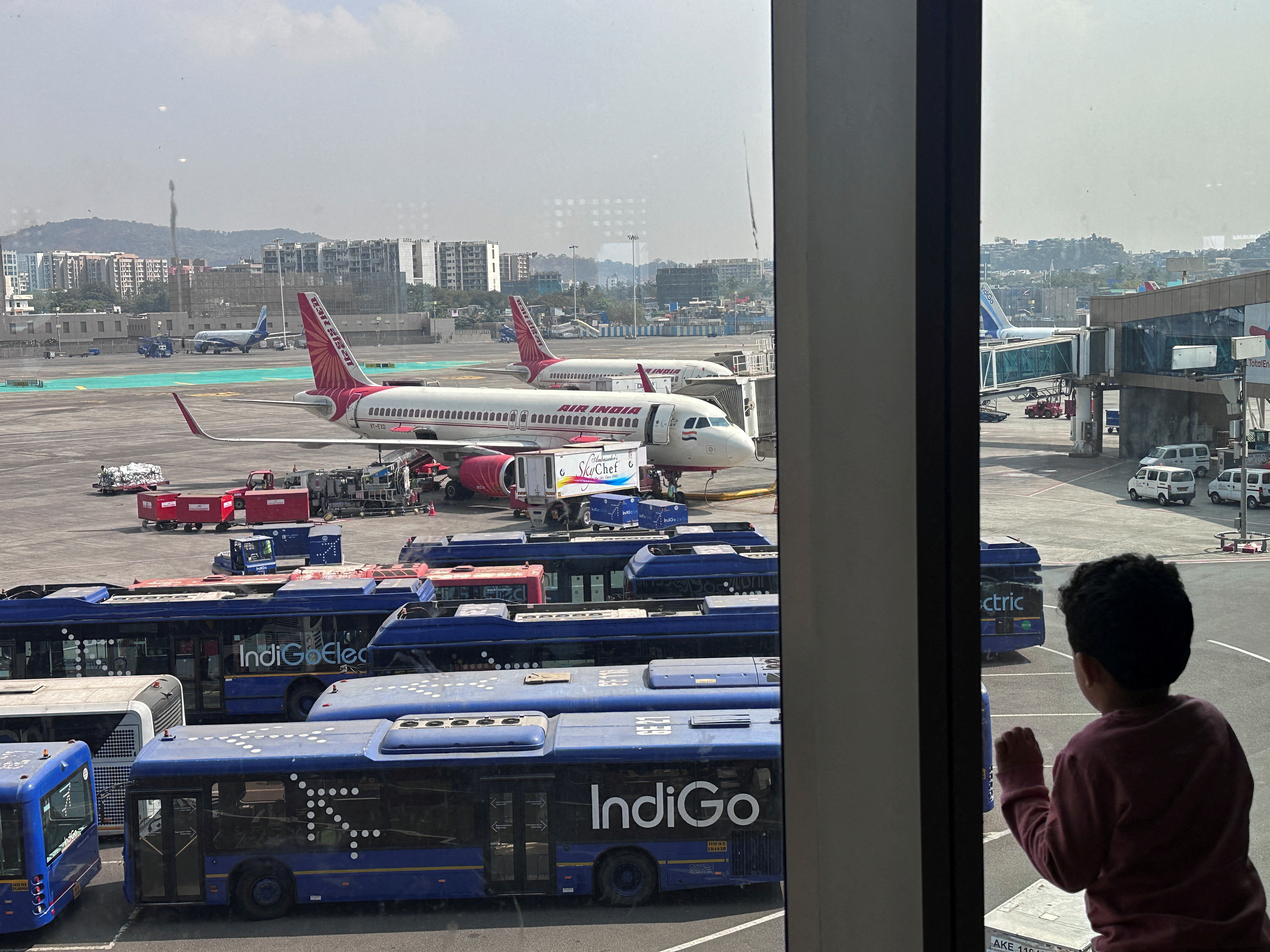 A boy looks at Air India airline passenger aircrafts parked at the Chhatrapati Shivaji Maharaj International Airport in Mumbai