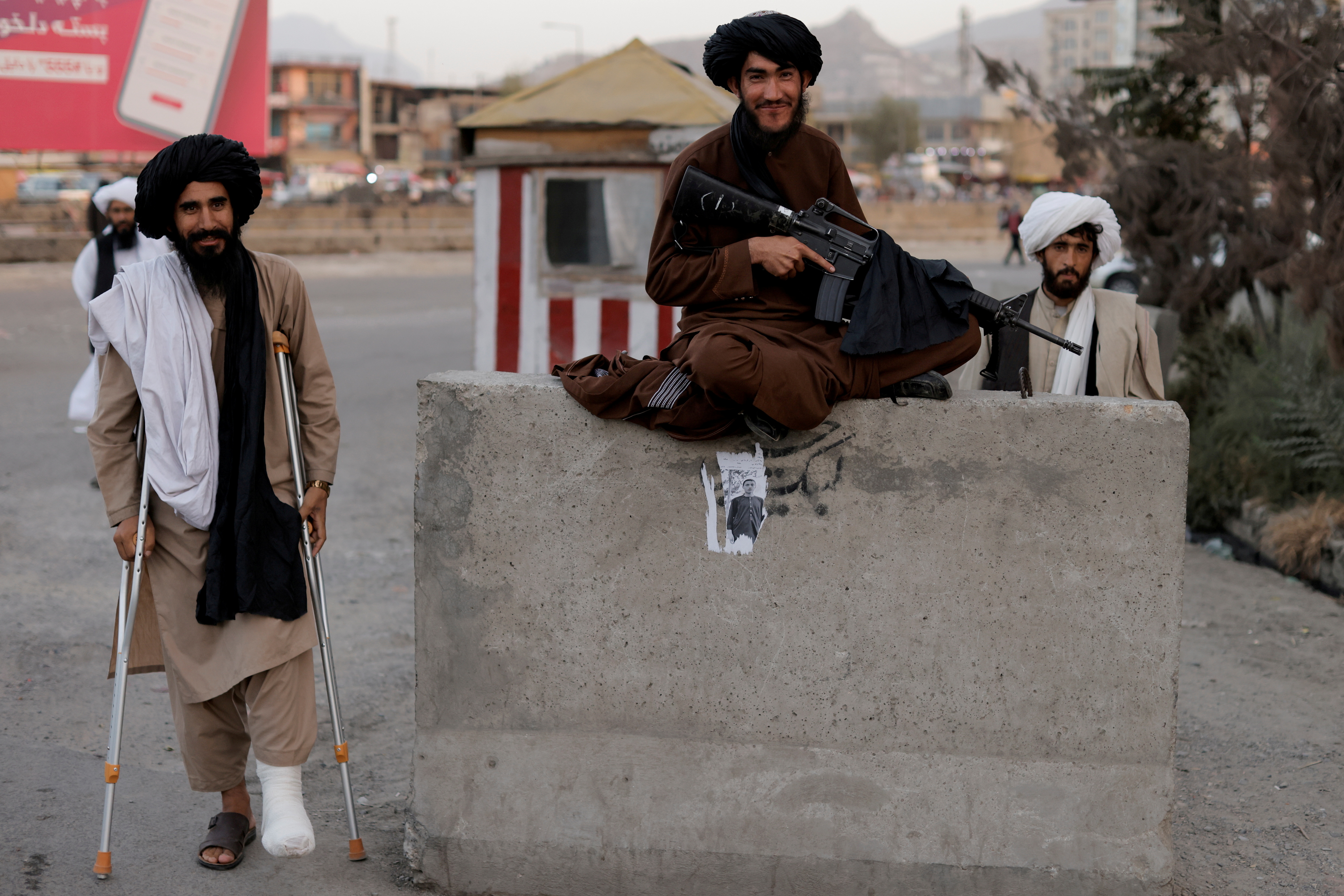 Taliban fighter Mira Jan Himmat, 30, and Rafiullah, 26, from Helmand province smile as they stand guard in a checkpoint in Kabul, Afghanistan October 5, 2021. REUTERS/Jorge Silva/File Photo