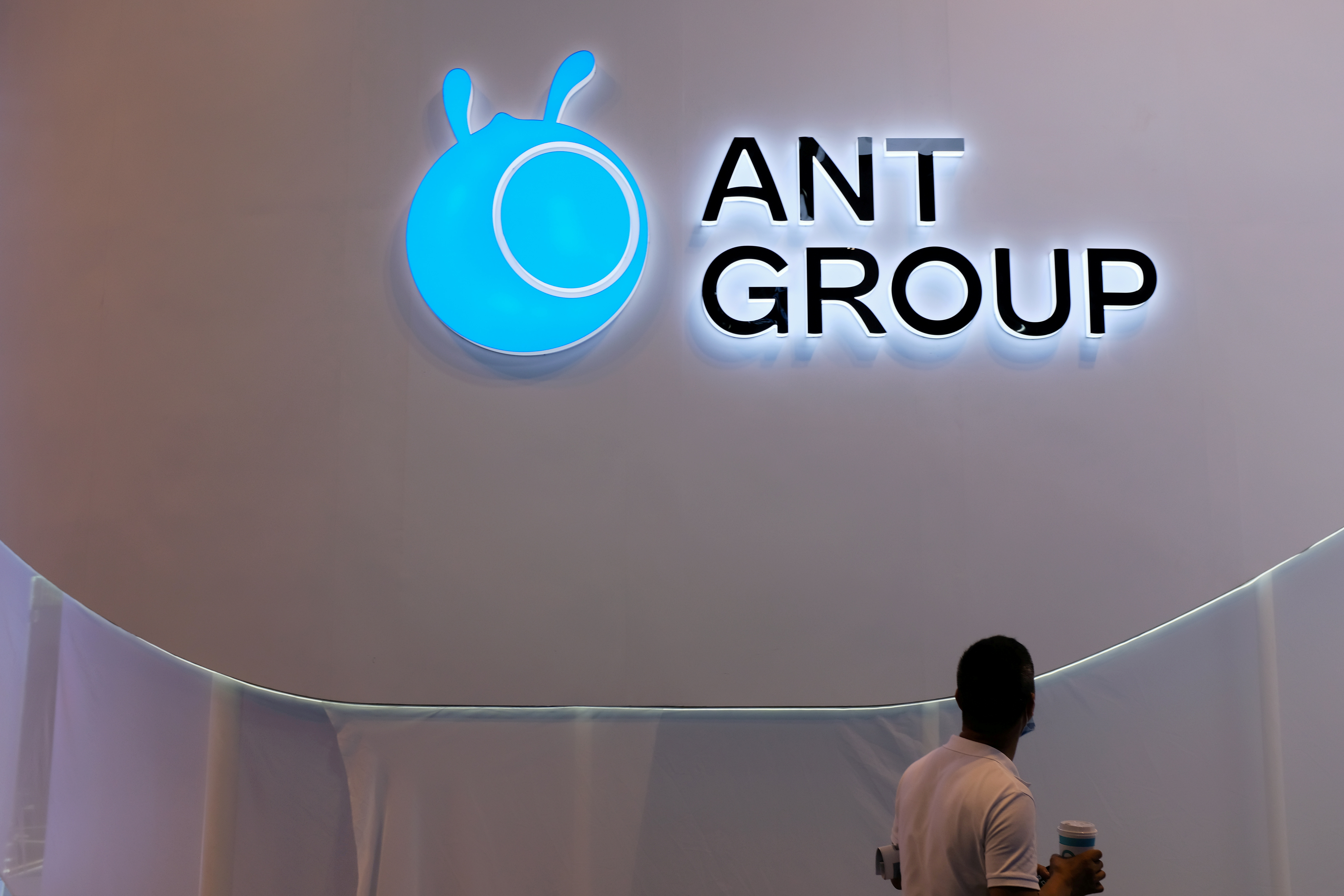 A man walks past an Ant Group logo in Shanghai