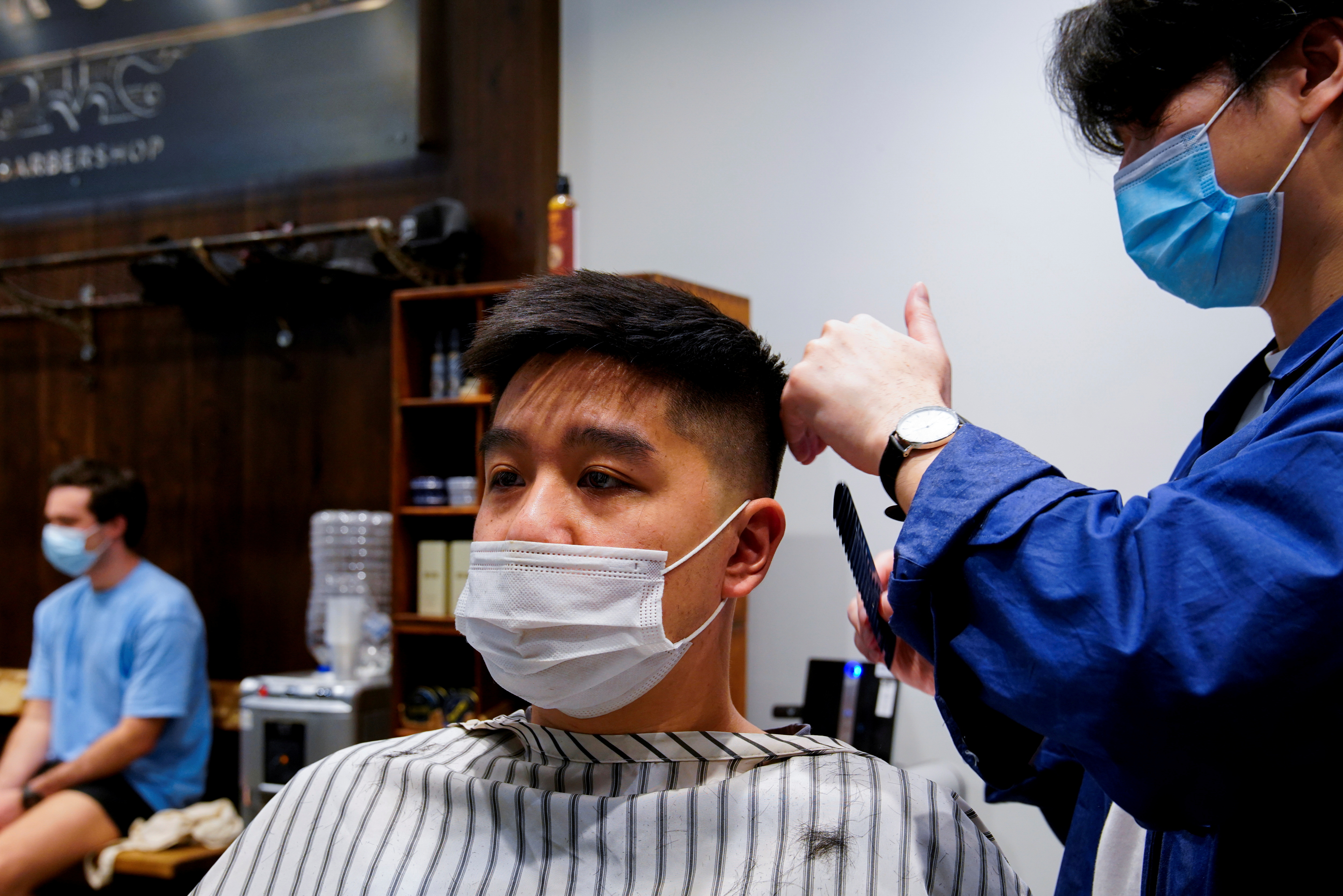 Patrick Vo gets his hair cut on the first day of eased coronavirus disease (COVID-19) regulations, following a lockdown to curb an outbreak, in Melbourne, Australia, October 22, 2021. REUTERS/Sandra Sanders