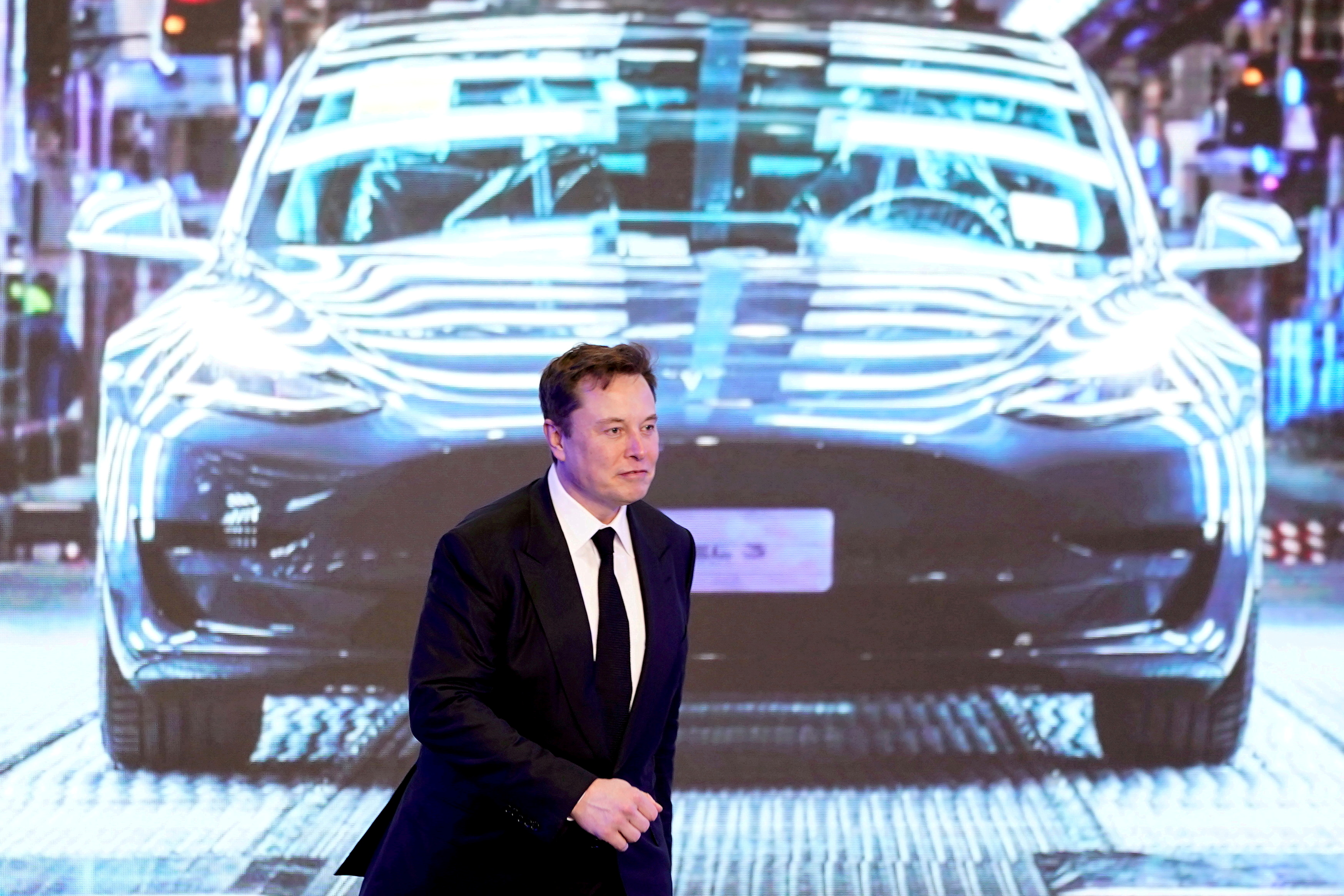 Tesla Inc CEO Elon Musk walks next to a screen showing an image of Tesla Model 3 car during an opening ceremony for Tesla China-made Model Y program in Shanghai, China January 7, 2020. REUTERS/Aly Song/File Photo