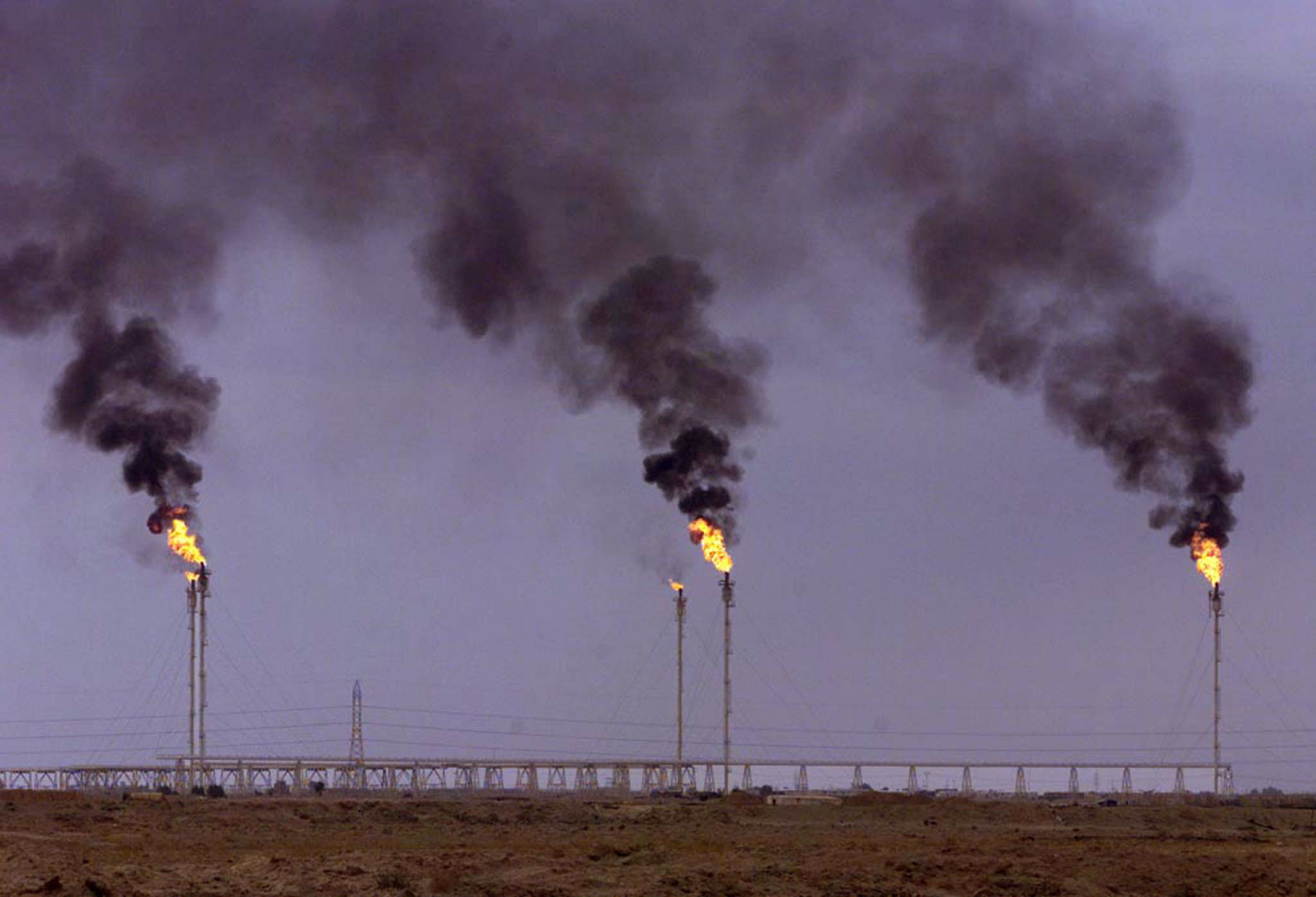 Three chimneys belch flames and smoke out of an oil refinery in the area of Basrah southern Iraq. Th..