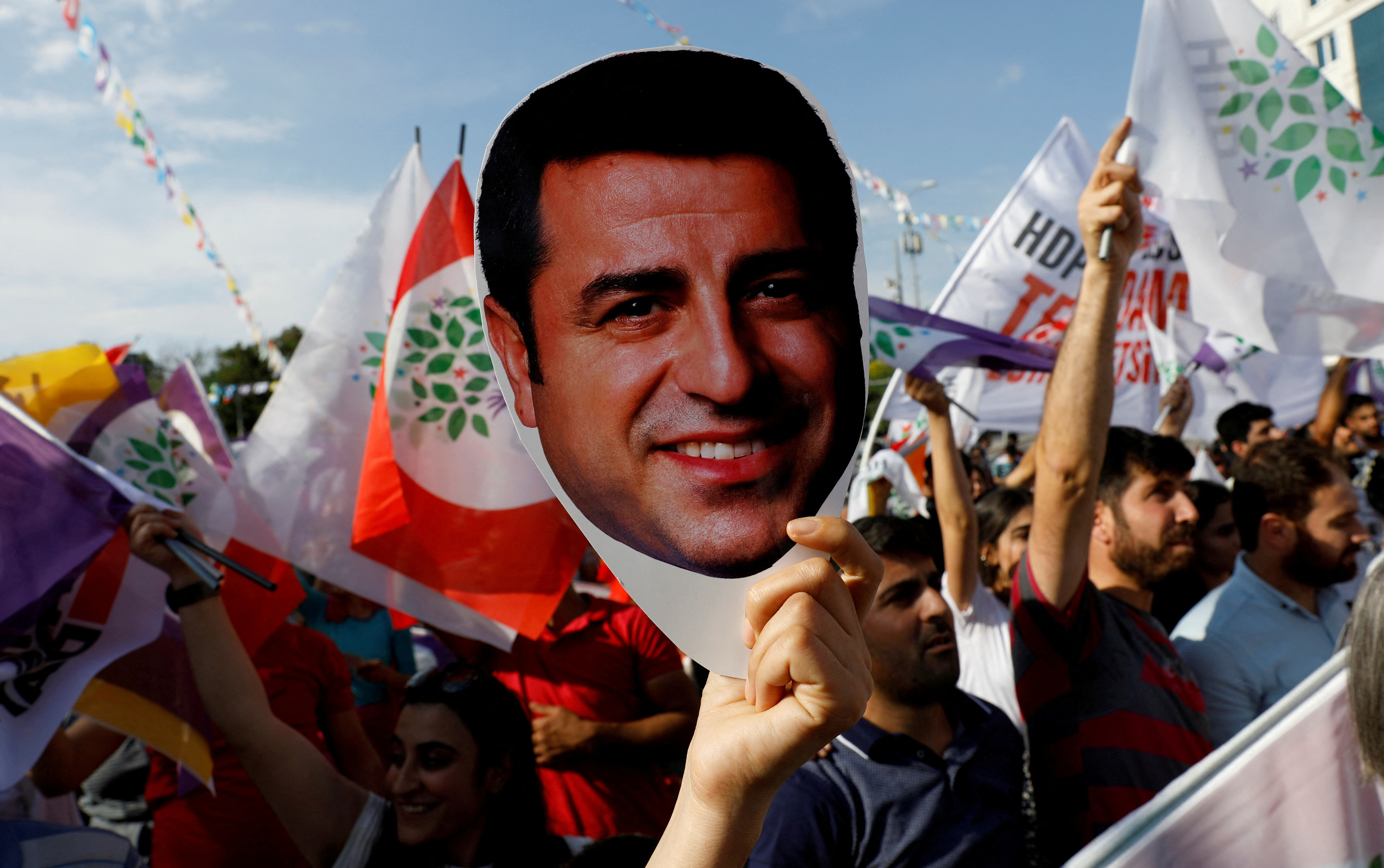 A supporter of Turkey's main pro-Kurdish Peoples' Democratic Party holds a mask of their jailed former leader and presidential candidate Selahattin Demirtas during a rally in Ankara