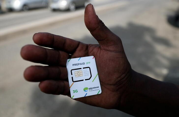 A customer holds a 3G prepaid sim card after buying the service from an Ethio-Telecom shop in Addis Ababa